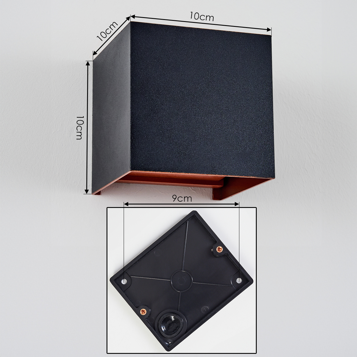 Quadratische schwarze Wandleuchte mit kupferfarbenem Boden. Darunter eine rautenförmige schwarze Montageplatte mit Maßen.