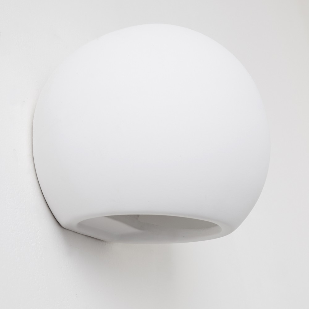 Eine weiße, kugelförmige Wandleuchte ist an einer weißen Wand montiert. Die Lampe hat eine abgerundete Form mit offenem Boden.