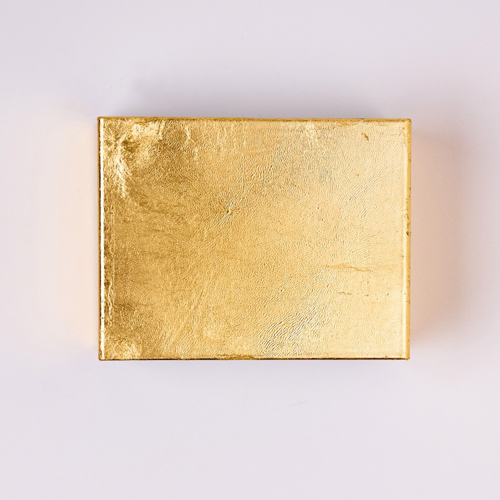 Ein quadratisches Objekt mit goldener Textur auf weißem Hintergrund. Das Gold hat ein leicht gealtertes Aussehen.