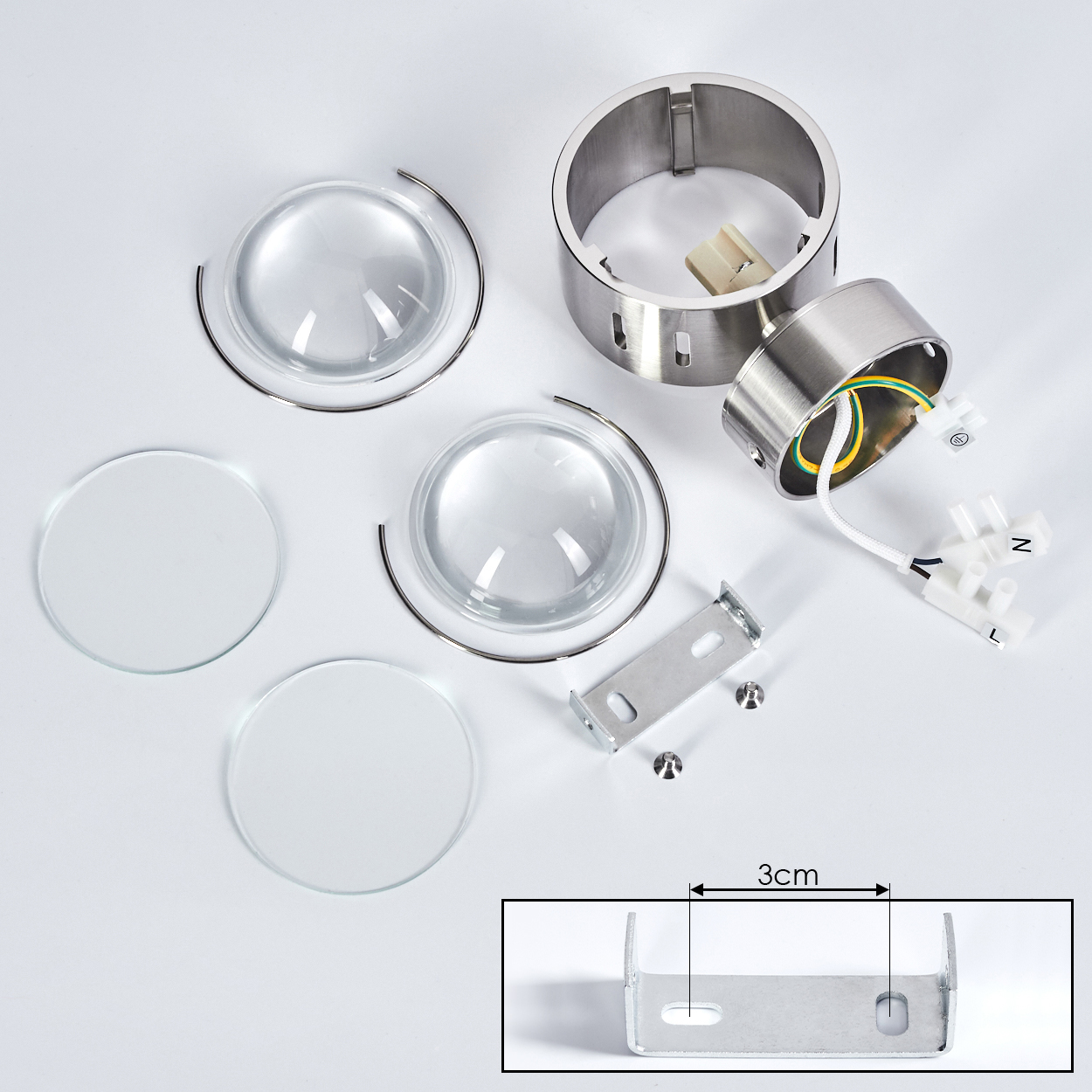 Zerlegte Leuchtenkomponenten auf Weiß. Enthält Linsen, Metallringe, Gehäuse, Halterung, Drähte und Schrauben. Eine 3cm Halterung ist gezeigt.