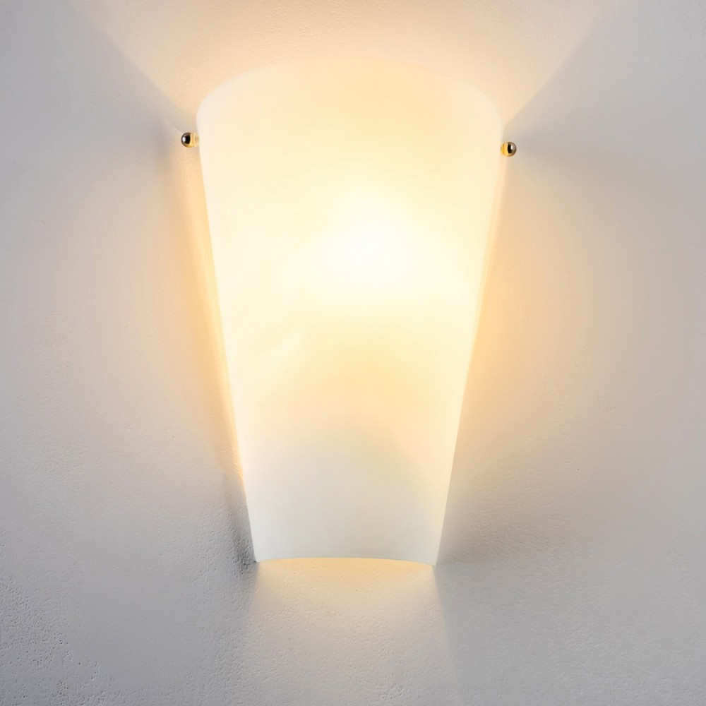 Eine weiße, an der Wand montierte Leuchte mit warmem Schein. Die Leuchte ist gebogen und hat zwei kleine goldene Akzente.