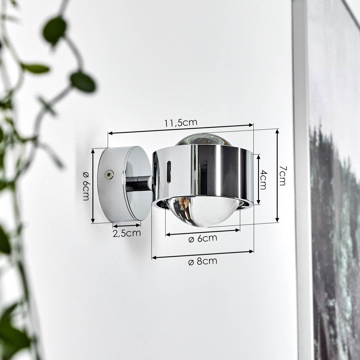 Eine verchromte Wandleuchte mit klarem Glas. Maße sind beschriftet: 11,5 cm, 7 cm, 4 cm, 6 cm, 8 cm und 2,5 cm. An einer weißen Wand montiert.