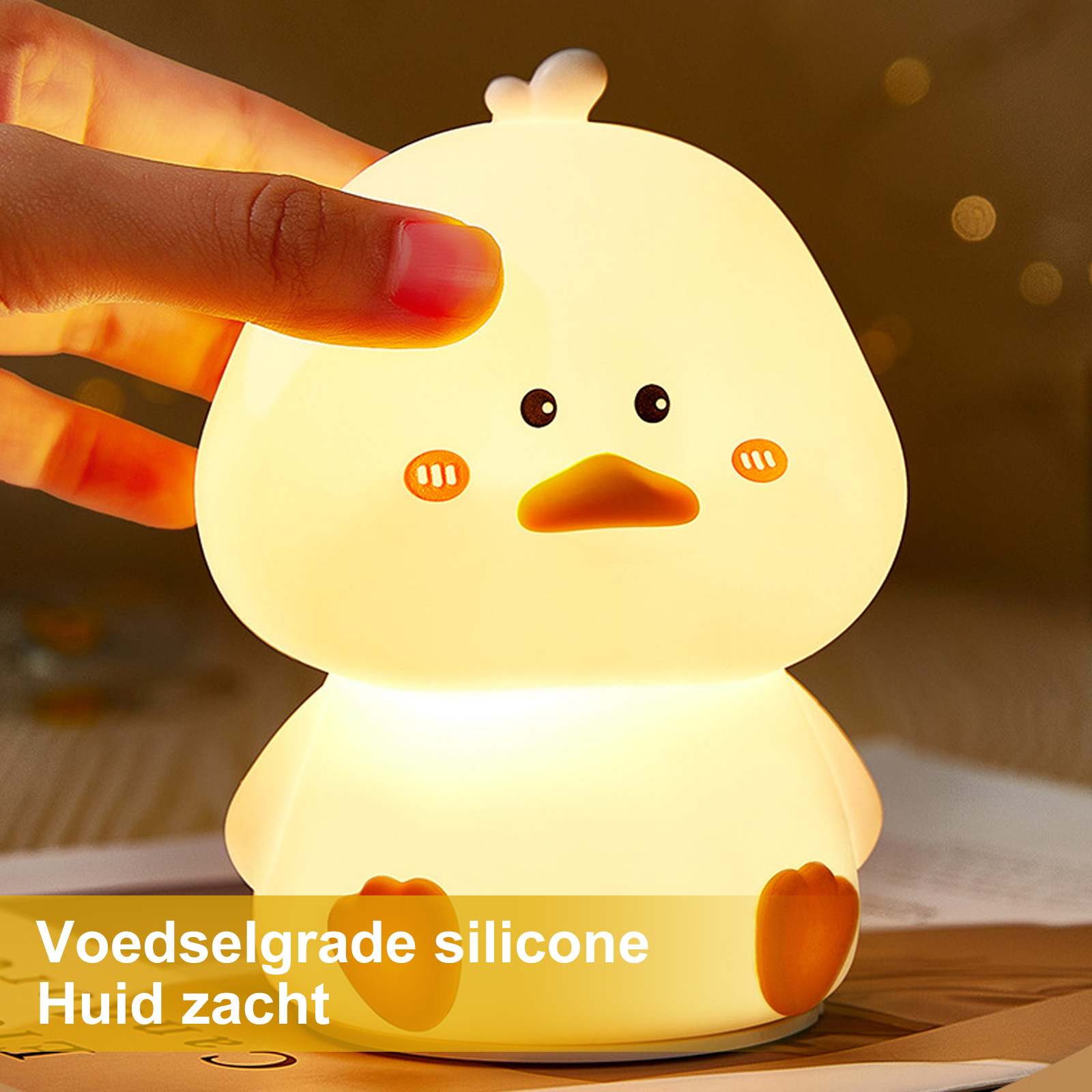 Ein gelbes, ente-förmiges Nachtlicht leuchtet. Eine Hand berührt die Oberseite der Lampe. Der Hintergrund ist unscharf und dunkel.