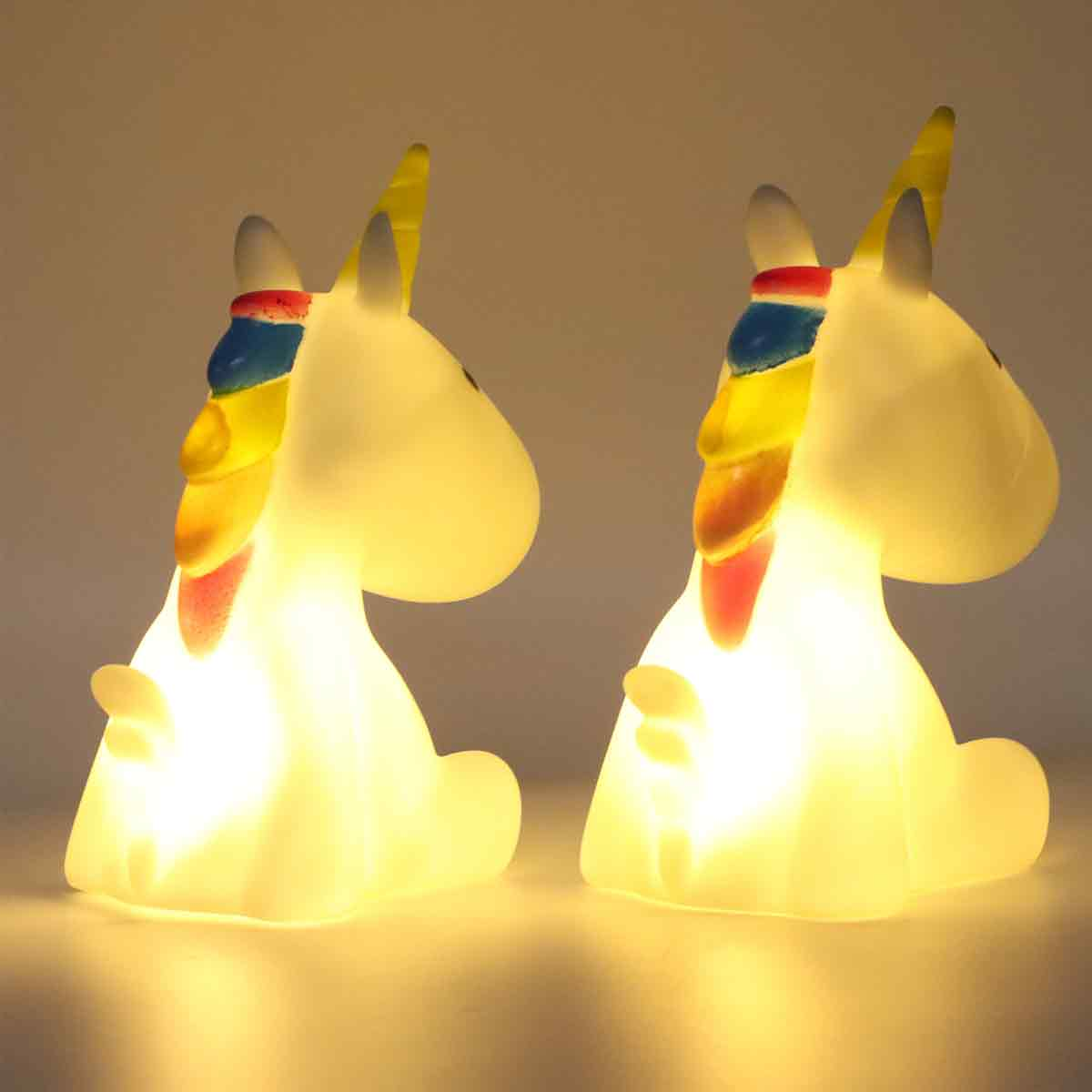 Zwei leuchtende Einhornlampen nebeneinander. Jedes hat eine Regenbogenmähne und ein gelbes Horn. Der Hintergrund ist ein Lichtverlauf.
