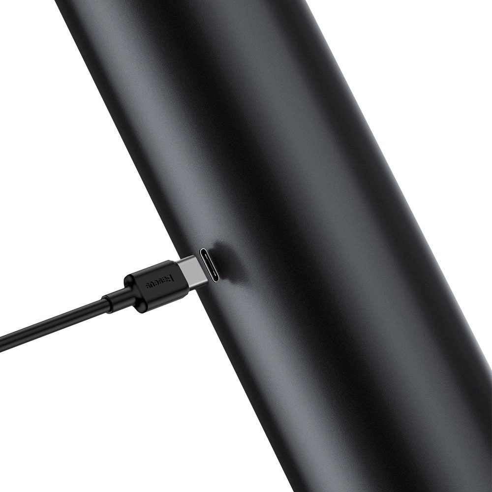 Un primo piano di un dispositivo cilindrico nero con una porta USB-C. Un cavo nero è collegato alla porta.