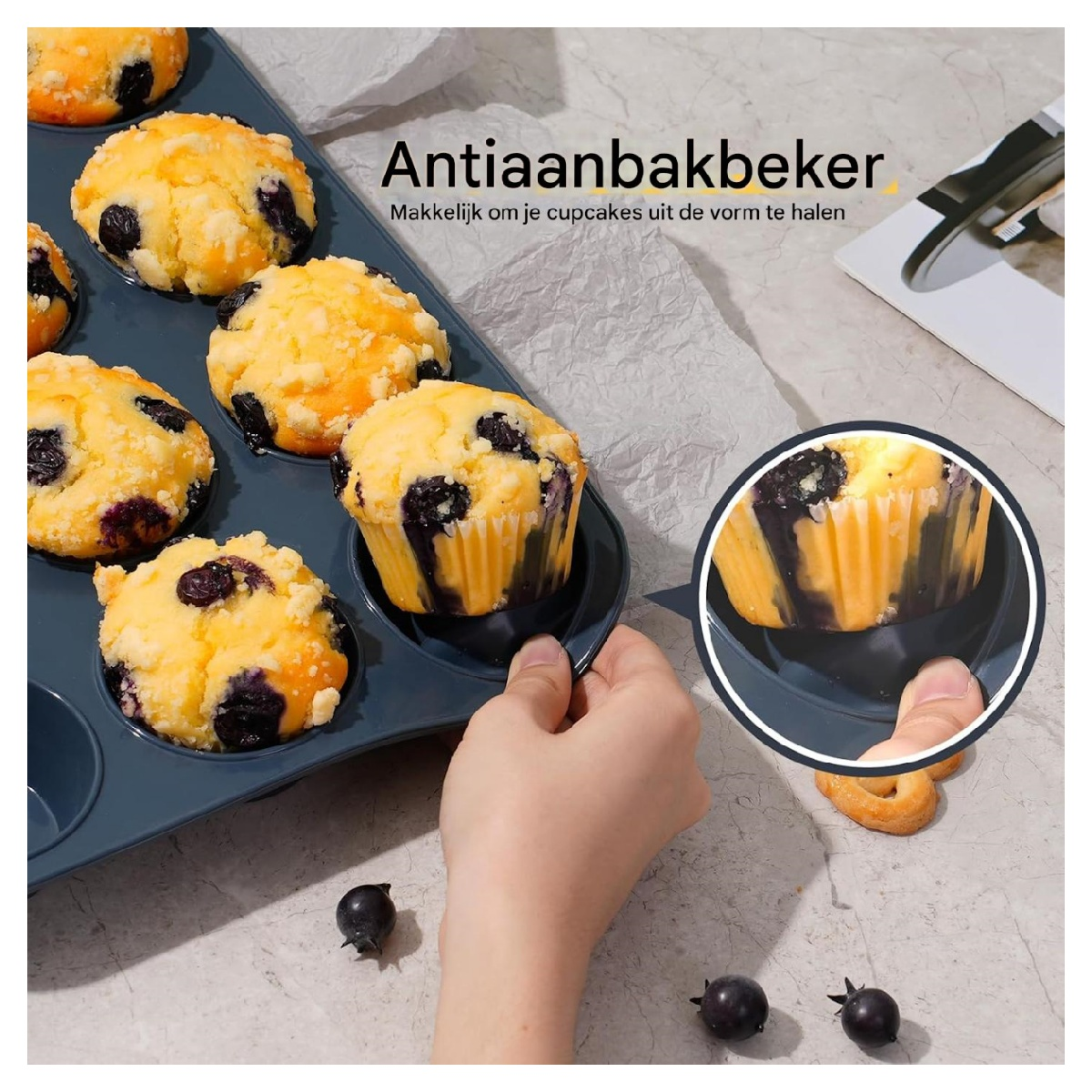 Blaubeermuffins in einem blauen Backblech. Eine Hand nimmt einen Muffin heraus. Beeren und ein Keks sind in der Nähe.
