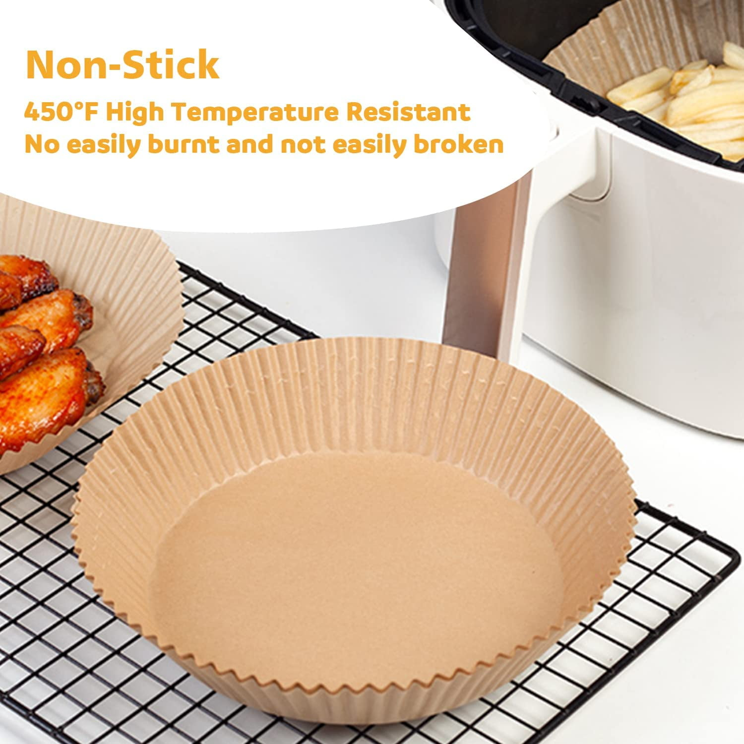 Ein Airfryer mit Papiereinlagen. Gebratene Hähnchenflügel und Pommes Frites sind sichtbar. Text: Antihaft, Hochtemperaturbeständig.