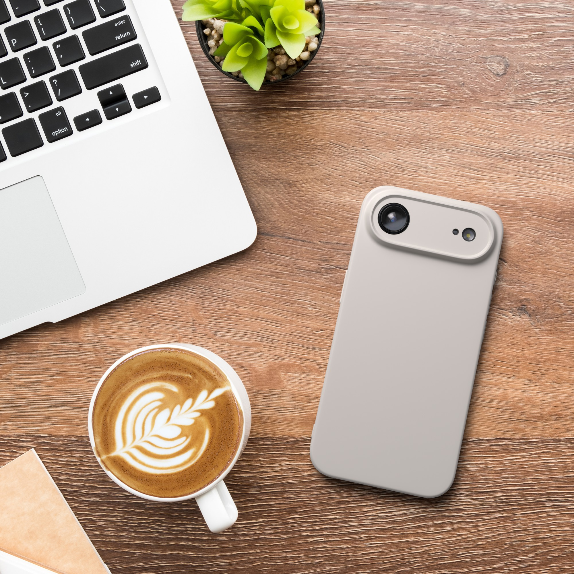 Draufsicht auf Laptop, Telefon, Kaffee und Pflanze auf einem Holzschreibtisch. Latte Art im Kaffee.