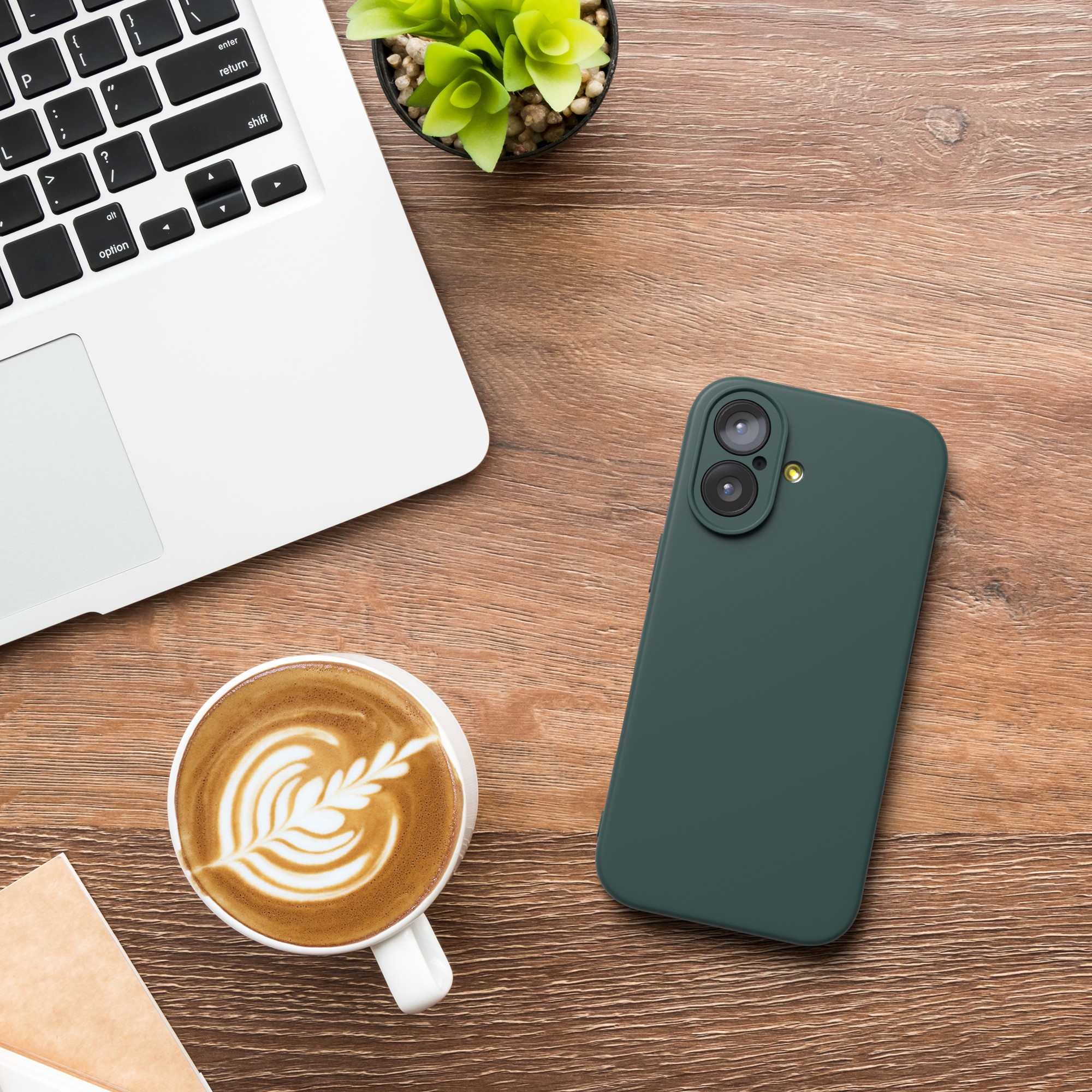 Ein Laptop, Kaffee mit Latte Art, ein grünes Telefon und eine kleine Pflanze stehen auf einem Holzschreibtisch.