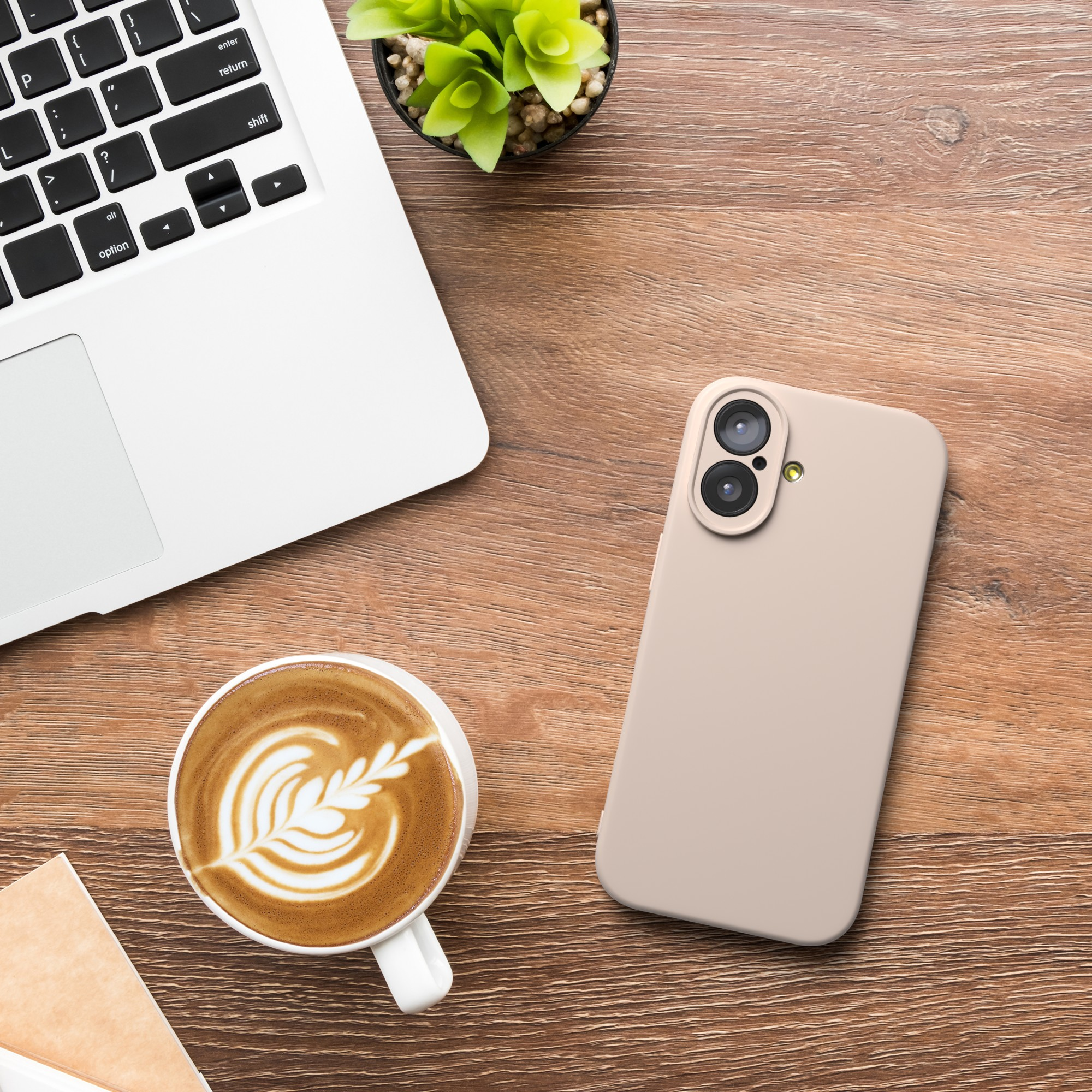 Laptop, Kaffee mit Latte Art, Telefon und Pflanze auf einem Holzschreibtisch. Die Szene ist von oben.