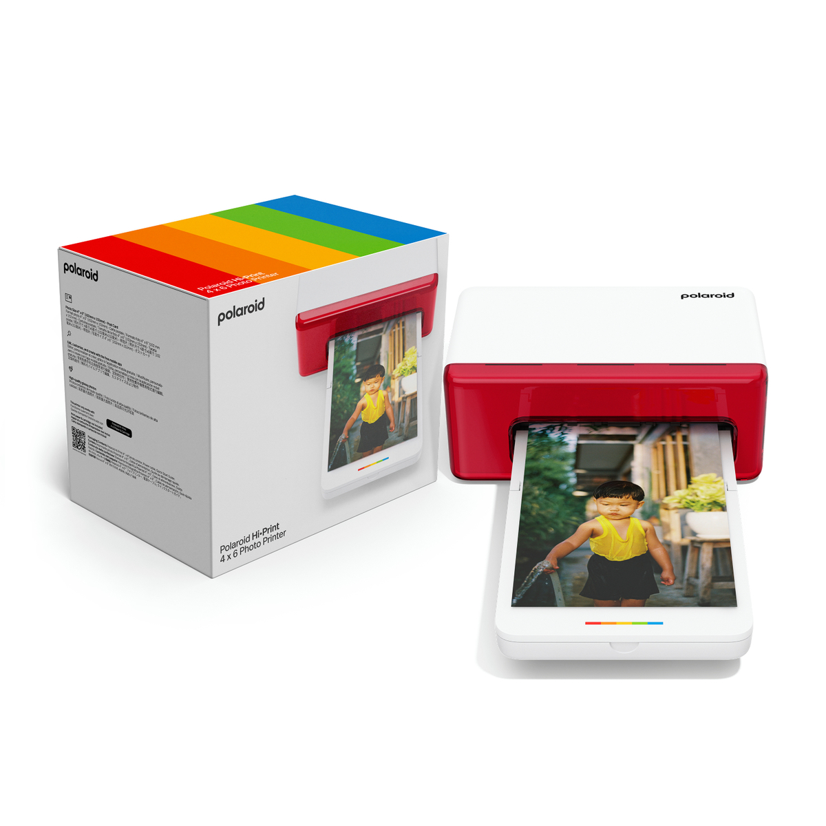 Drukarka fotograficzna Polaroid Hi-Print, pudełko i drukarka. Pudełko ma kolory tęczy, drukarka jest biało-czerwona. Zdjęcie się pojawia.