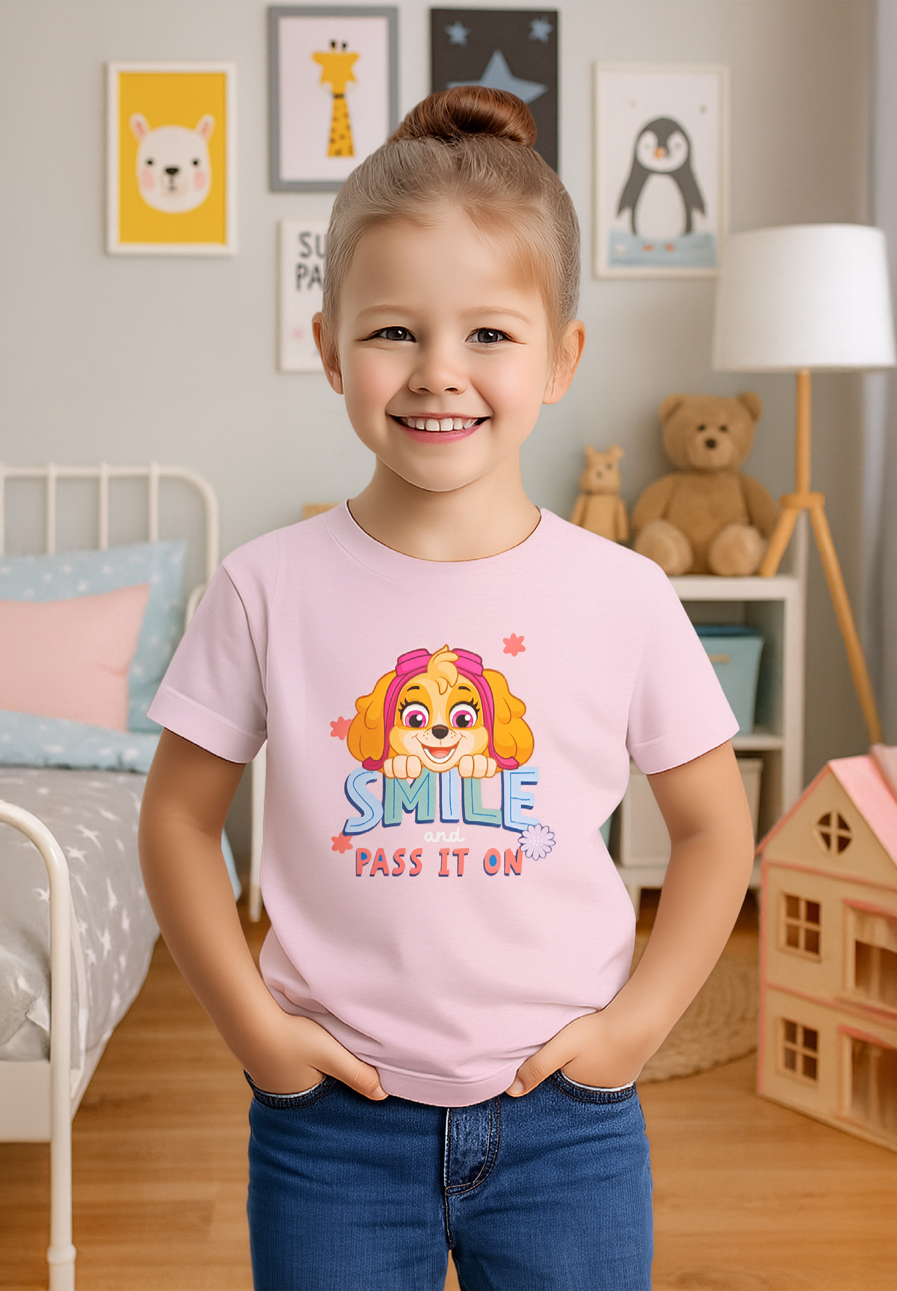 Ein lächelndes Mädchen trägt ein rosa Shirt mit einem Cartoon-Hund. Sie hat die Hände in den Taschen. Der Hintergrund ist ein Schlafzimmer.