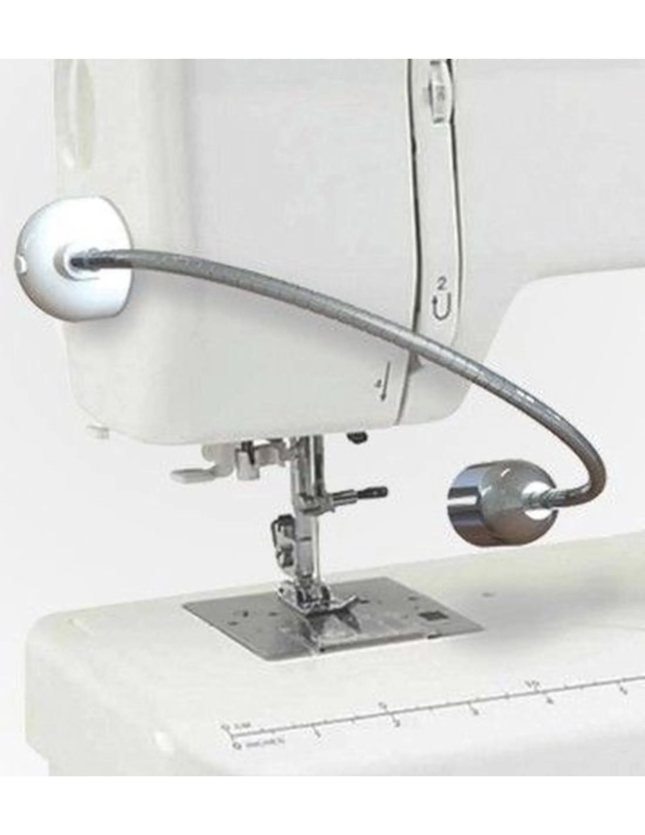 Een witte naaimachine met een flexibele lamp. De lamp is aan de machine bevestigd.