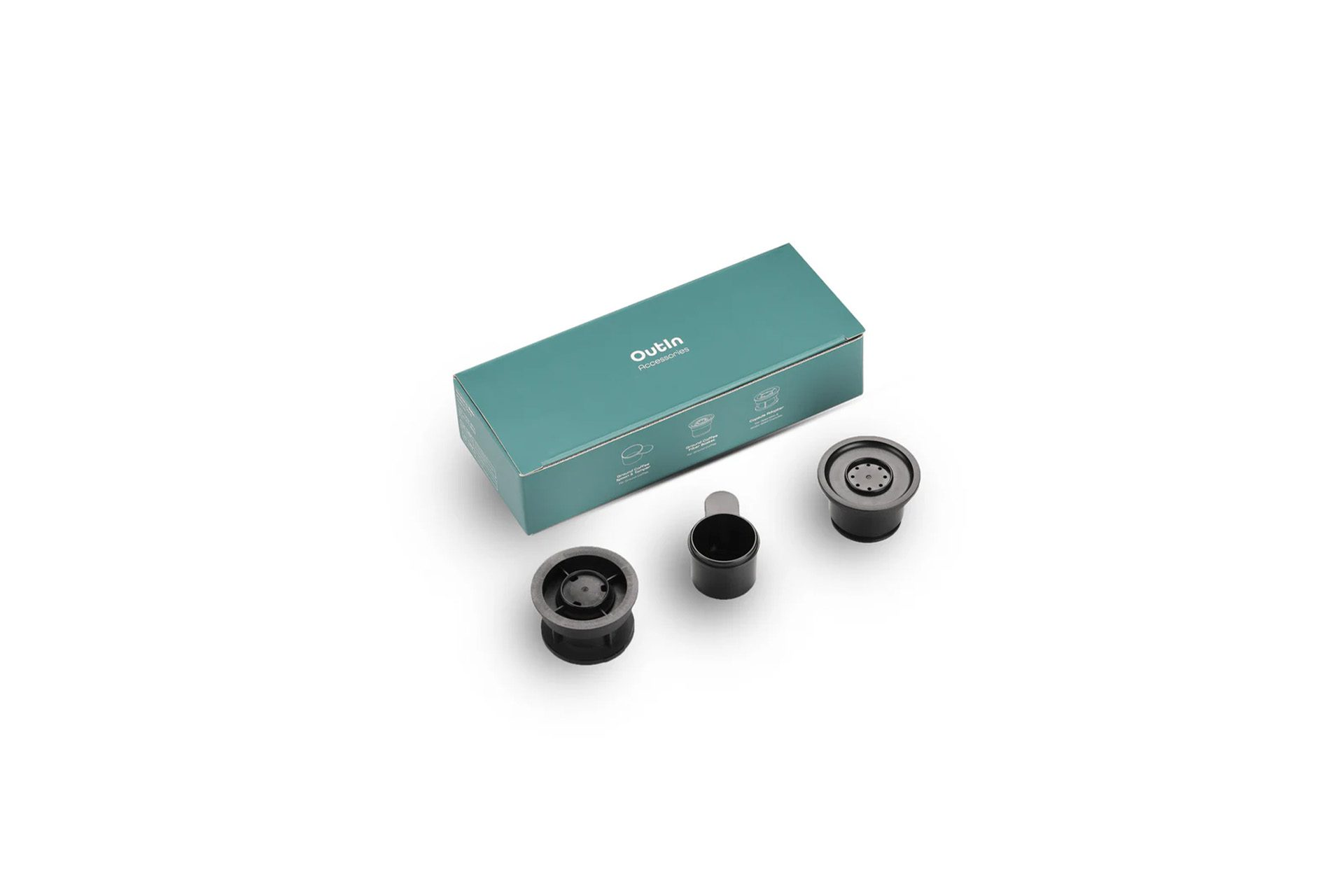 Eine teal-farbene Schachtel mit 'Outin Accessories' und drei schwarzen Kaffeezubehörteilen auf weißem Untergrund.
