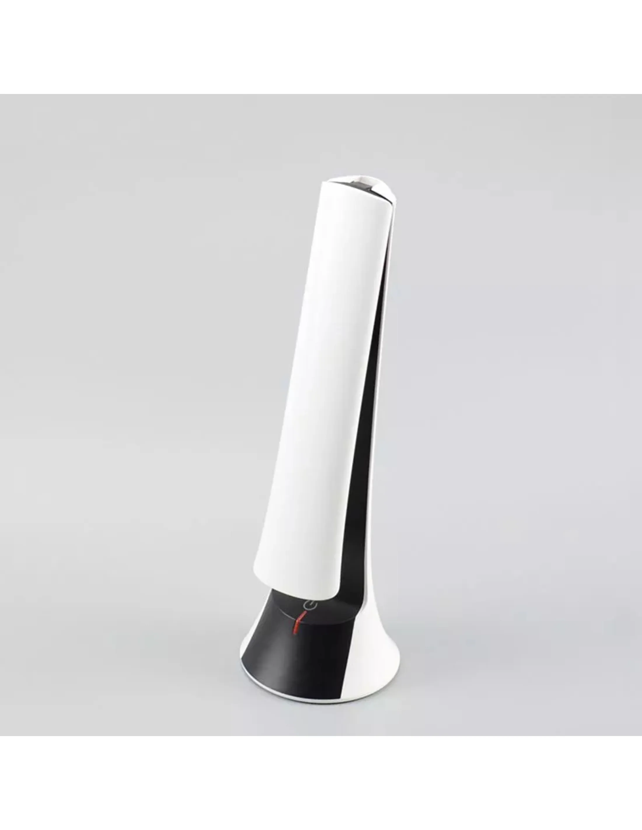 Een witte en zwarte moderne lamp staat op een grijze ondergrond. De lamp heeft een strak ontwerp.