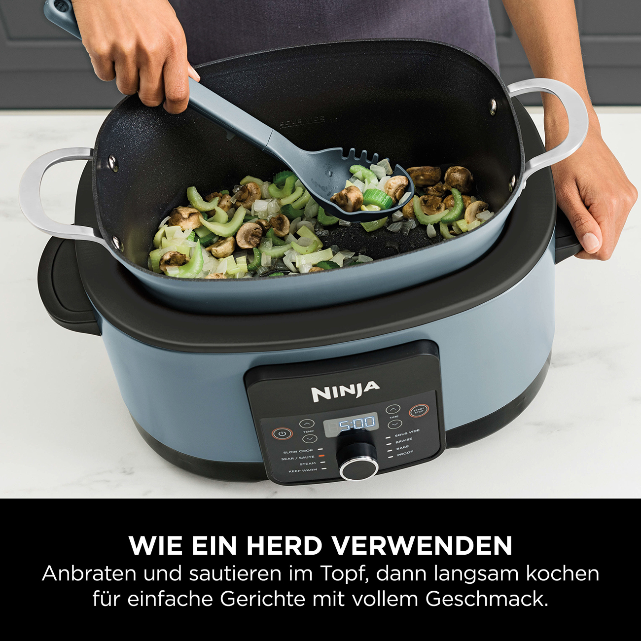 Een persoon roert groenten en champignons in een pan met een grijze lepel. De pan staat in een slowcooker.