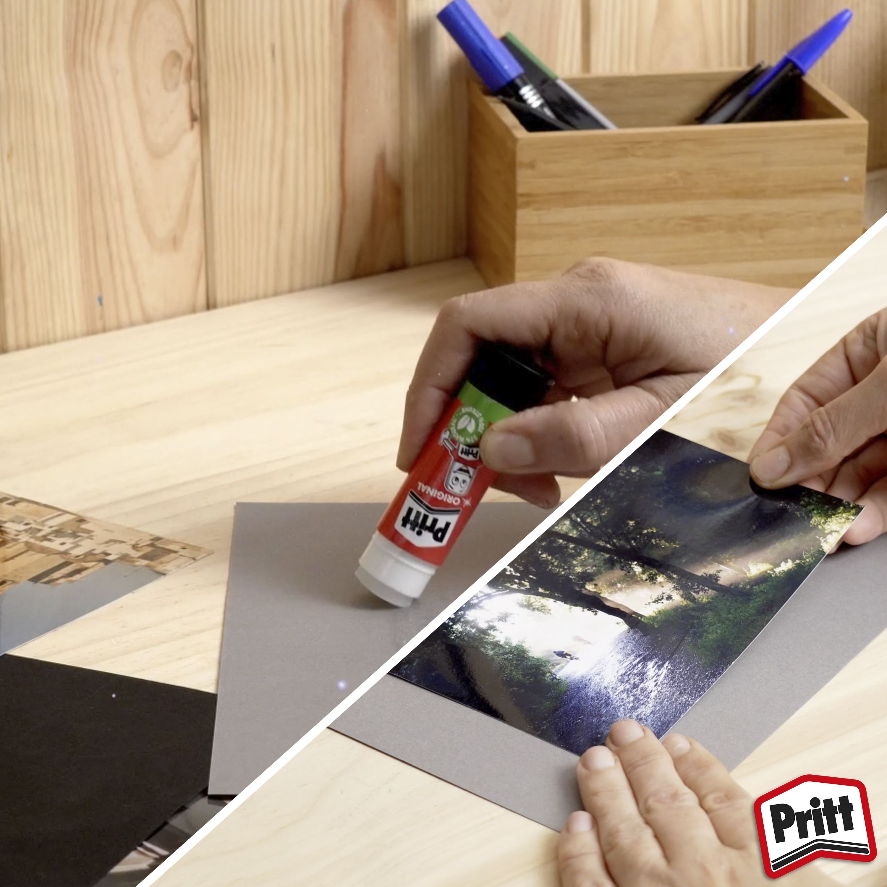 Hände verwenden Pritt-Kleber, um ein Foto auf graues Papier zu kleben. Holziger Hintergrund mit Stiften im Hintergrund.