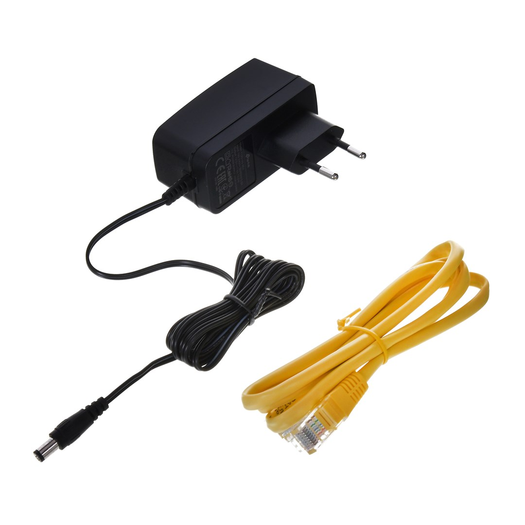 Czarny zasilacz, zwinięty czarny kabel i żółty kabel Ethernet na białym tle. Wszystko jest odizolowane.