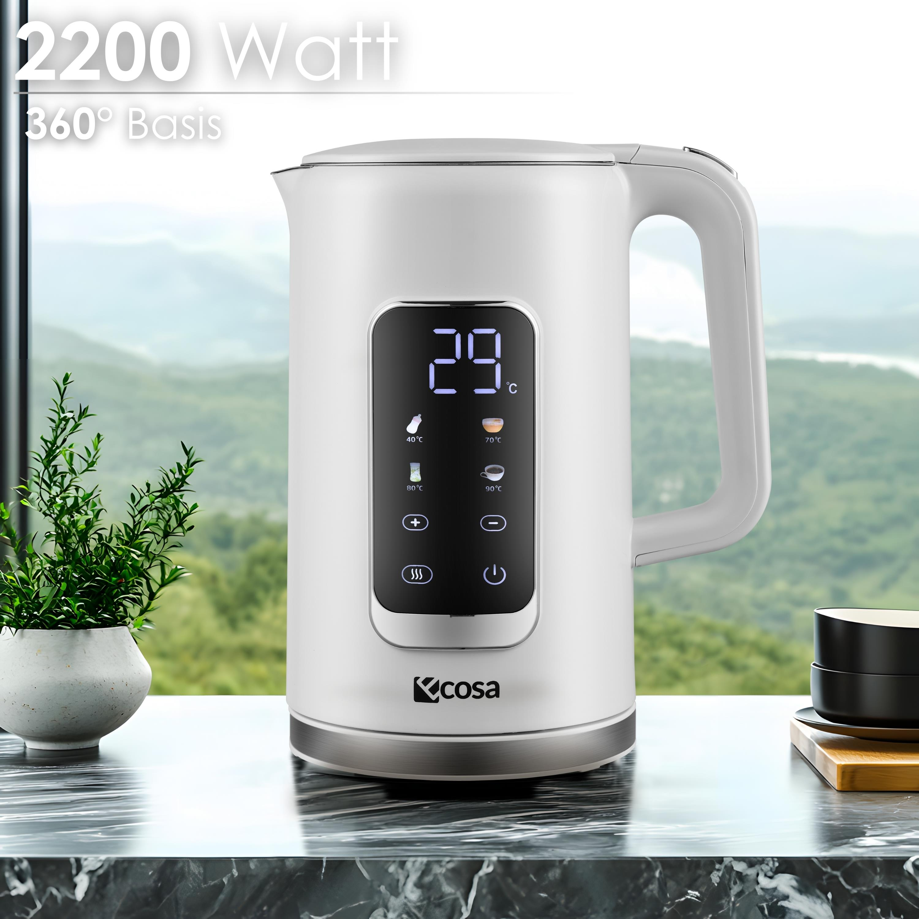Ein weißer Wasserkocher mit digitaler Anzeige, die 29 Grad Celsius anzeigt. Durch das Fenster ist eine grüne Landschaft zu sehen.