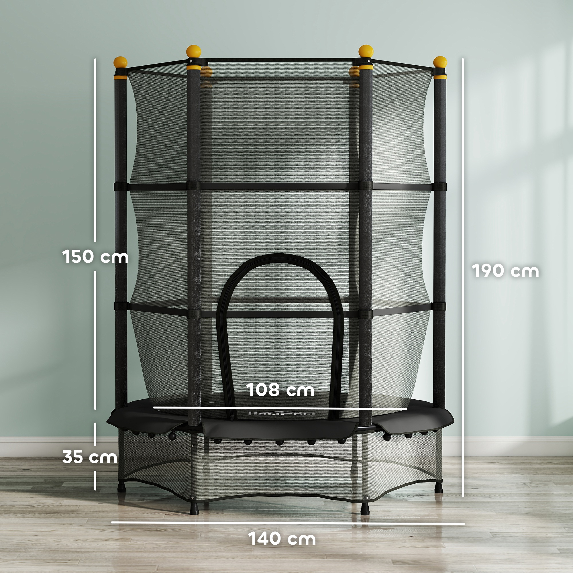 Un trampolino nero con rete di sicurezza, pali superiori gialli e dimensioni etichettate. Si trova in una stanza con parete verde chiaro e pavimento in legno.