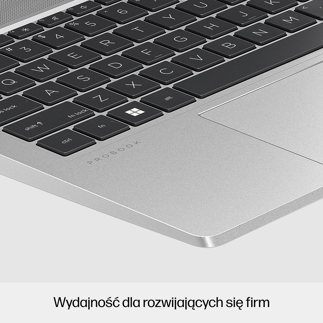 Zbliżenie klawiatury laptopa z czarnymi klawiszami i białymi literami. Powierzchnia jest srebrna, widoczne jest słowo 'PROBOOK'.