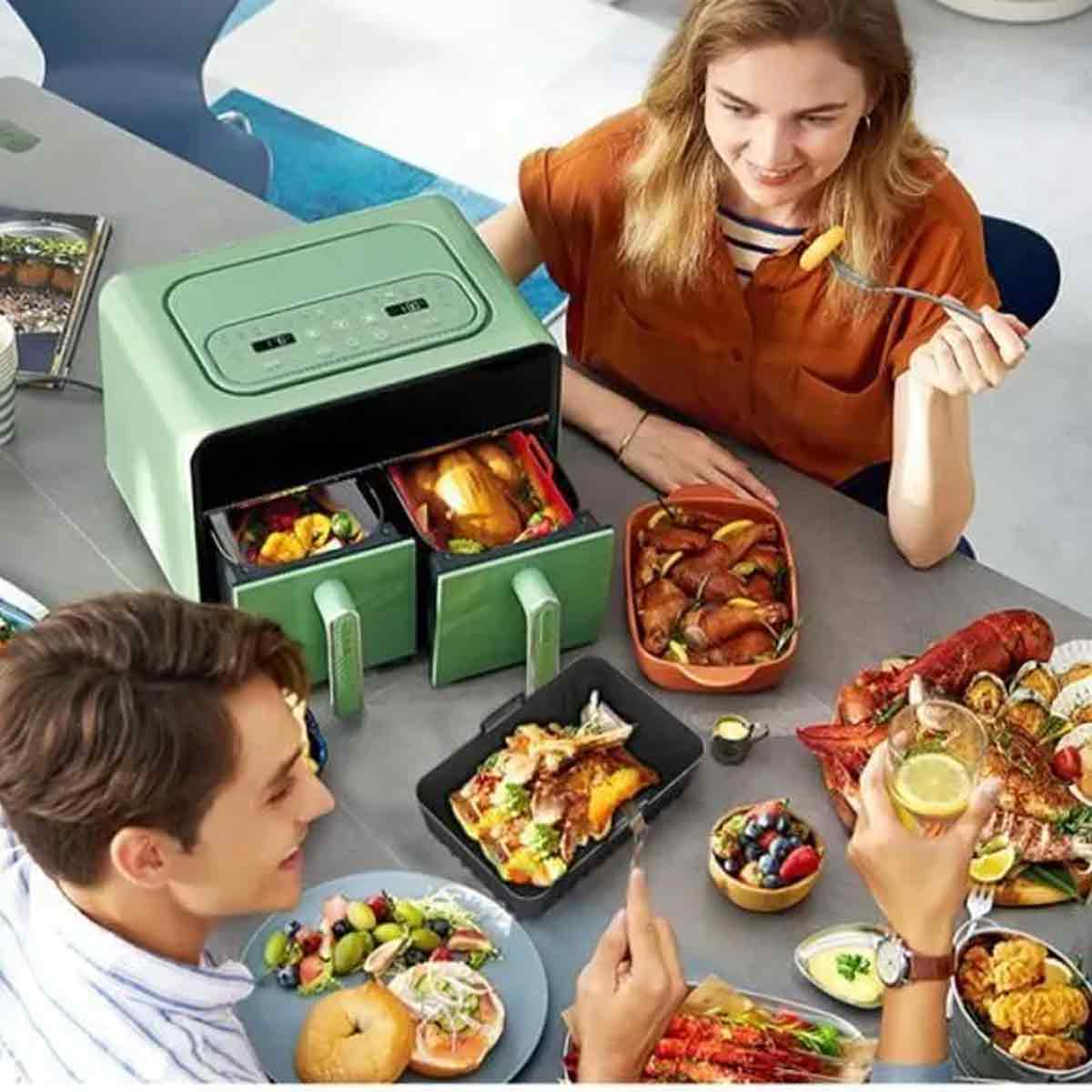 Menschen essen verschiedene Gerichte aus einer Heißluftfritteuse. Gerichte umfassen Hähnchen, Meeresfrüchte, Salat und Obst. Eine Frau isst eine Bratkartoffel.