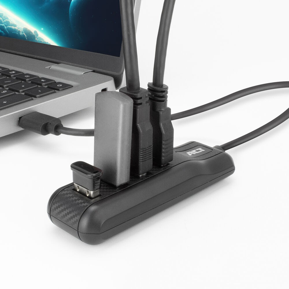 Ein Laptop, der mit einem schwarzen USB-Hub verbunden ist. Der Hub hat mehrere Anschlüsse und einen kleinen USB-Empfänger. Kabel sind angeschlossen.