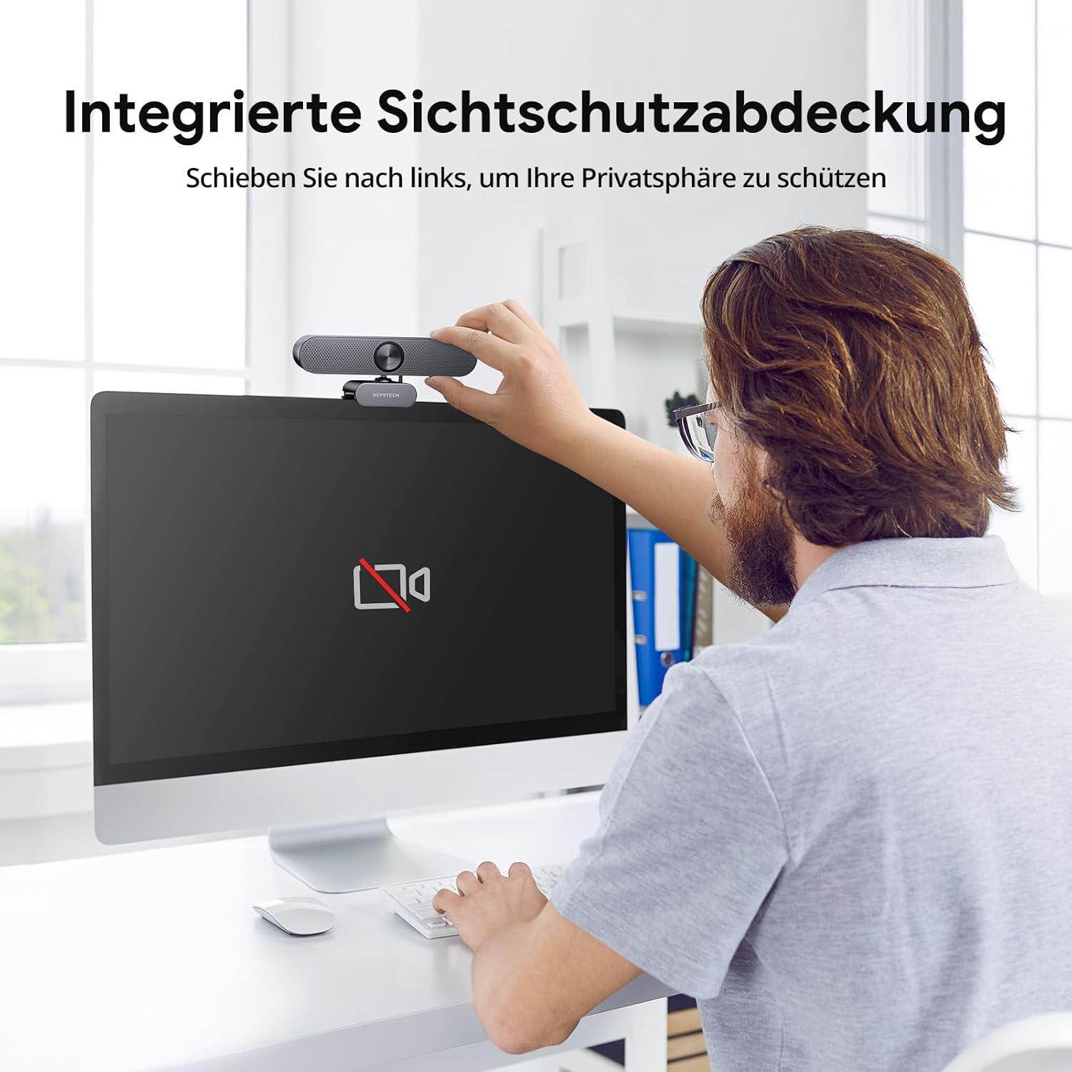 Mężczyzna umieszcza kamerę internetową na monitorze. Ekran wyświetla ikonę kamery z przekreśleniem. Tekst mówi: 'Zintegrowana osłona prywatności'.