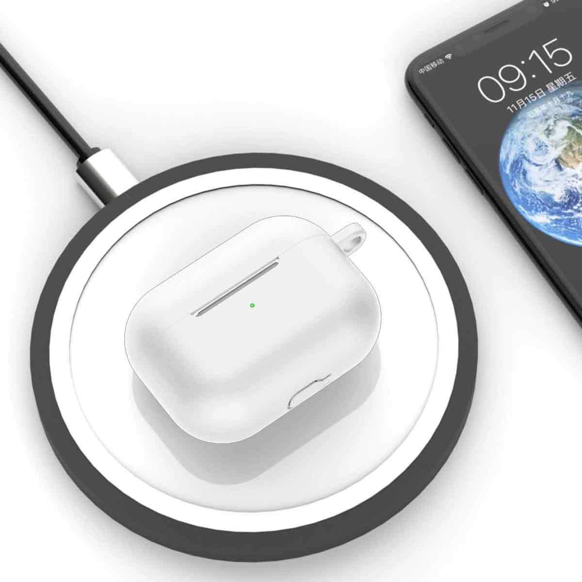 Weißes AirPods-Etui auf einem kabellosen Ladegerät, neben einem Telefon, das Uhrzeit und Datum anzeigt.