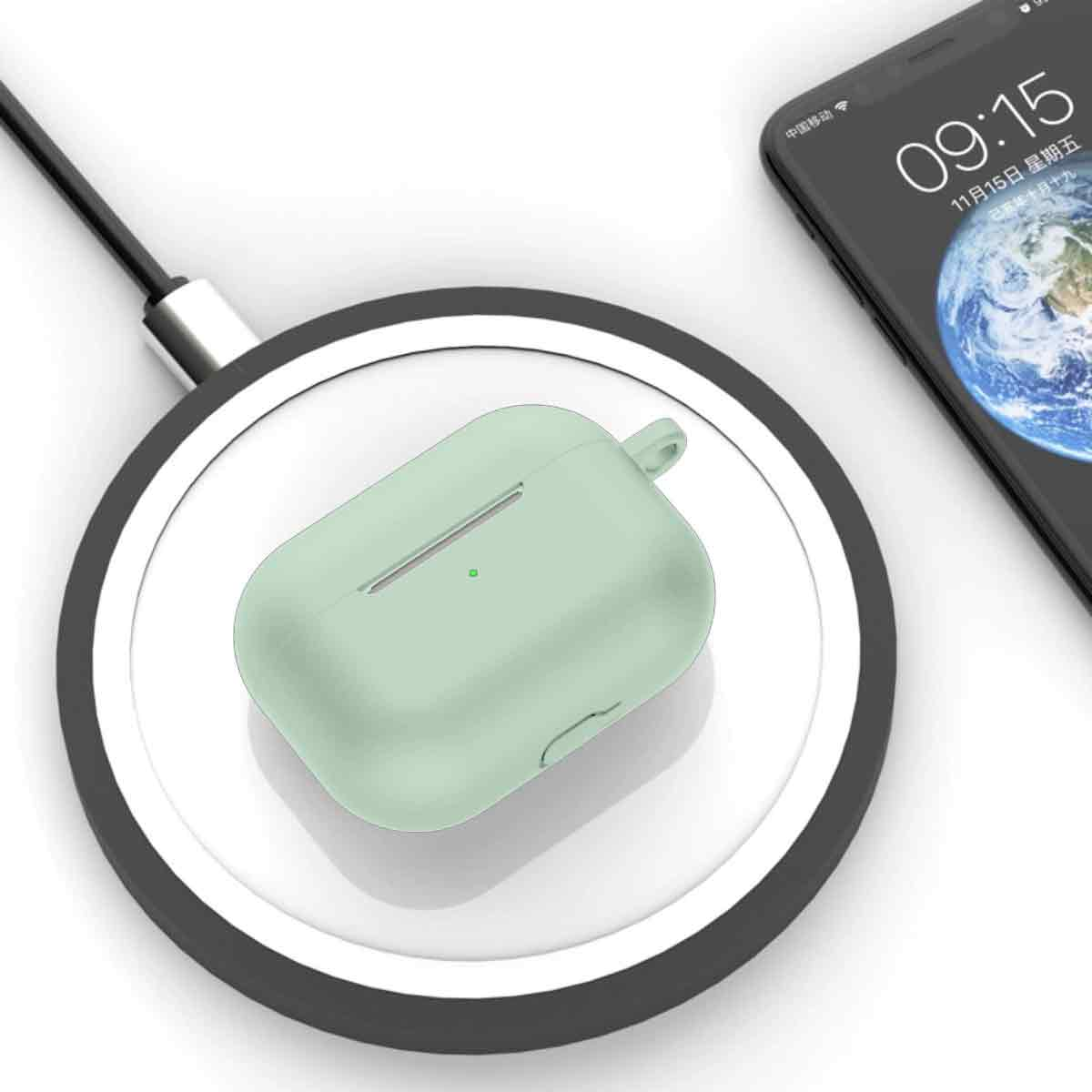 Ein mintgrünes Kopfhöreretui liegt auf einem kabellosen Ladegerät neben einem Smartphone, das Zeit und Datum anzeigt.