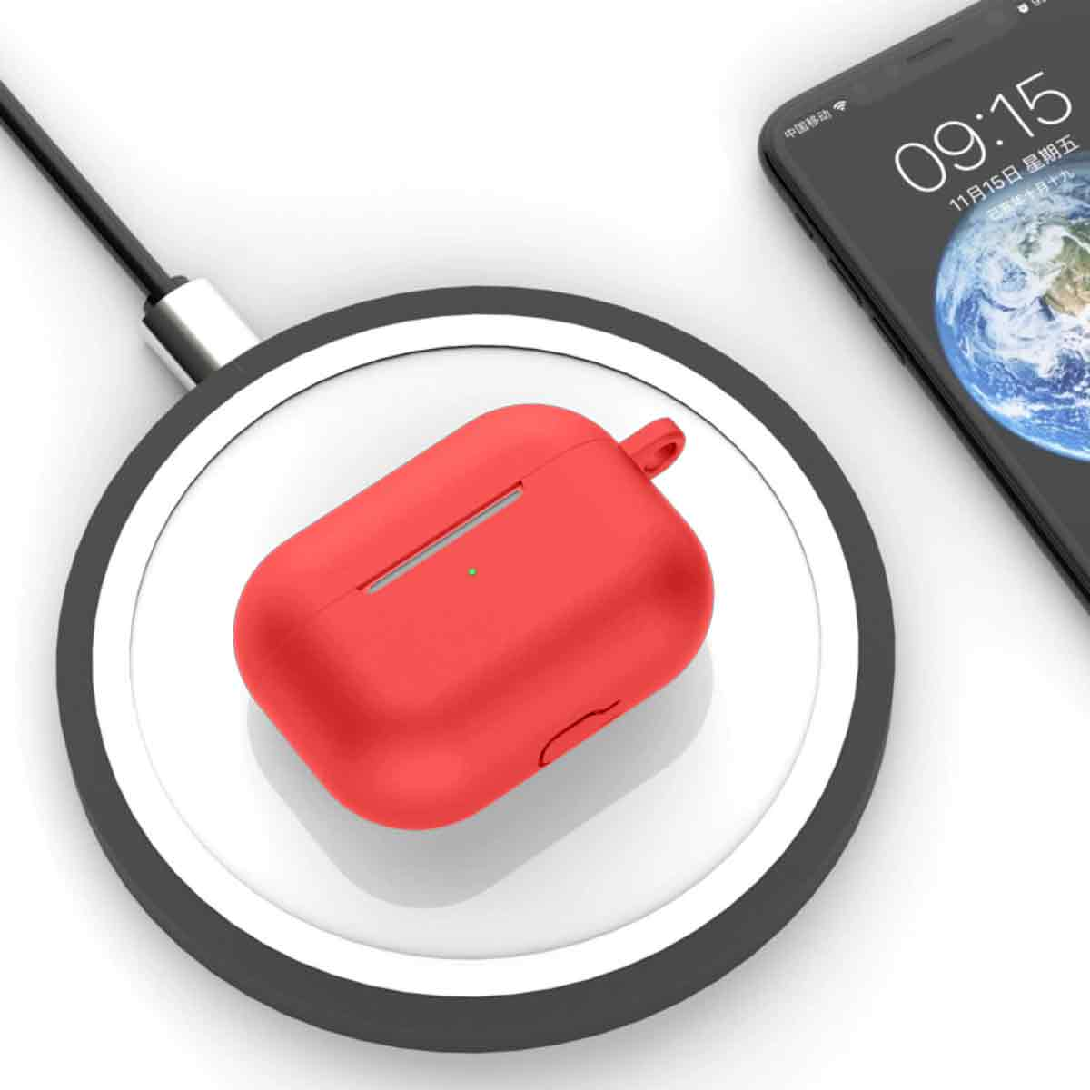 Ein rotes AirPods-Etui liegt auf einem kabellosen Ladegerät. Ein Smartphone zeigt 09:15 an. Das Ladegerät ist mit einem Kabel verbunden.