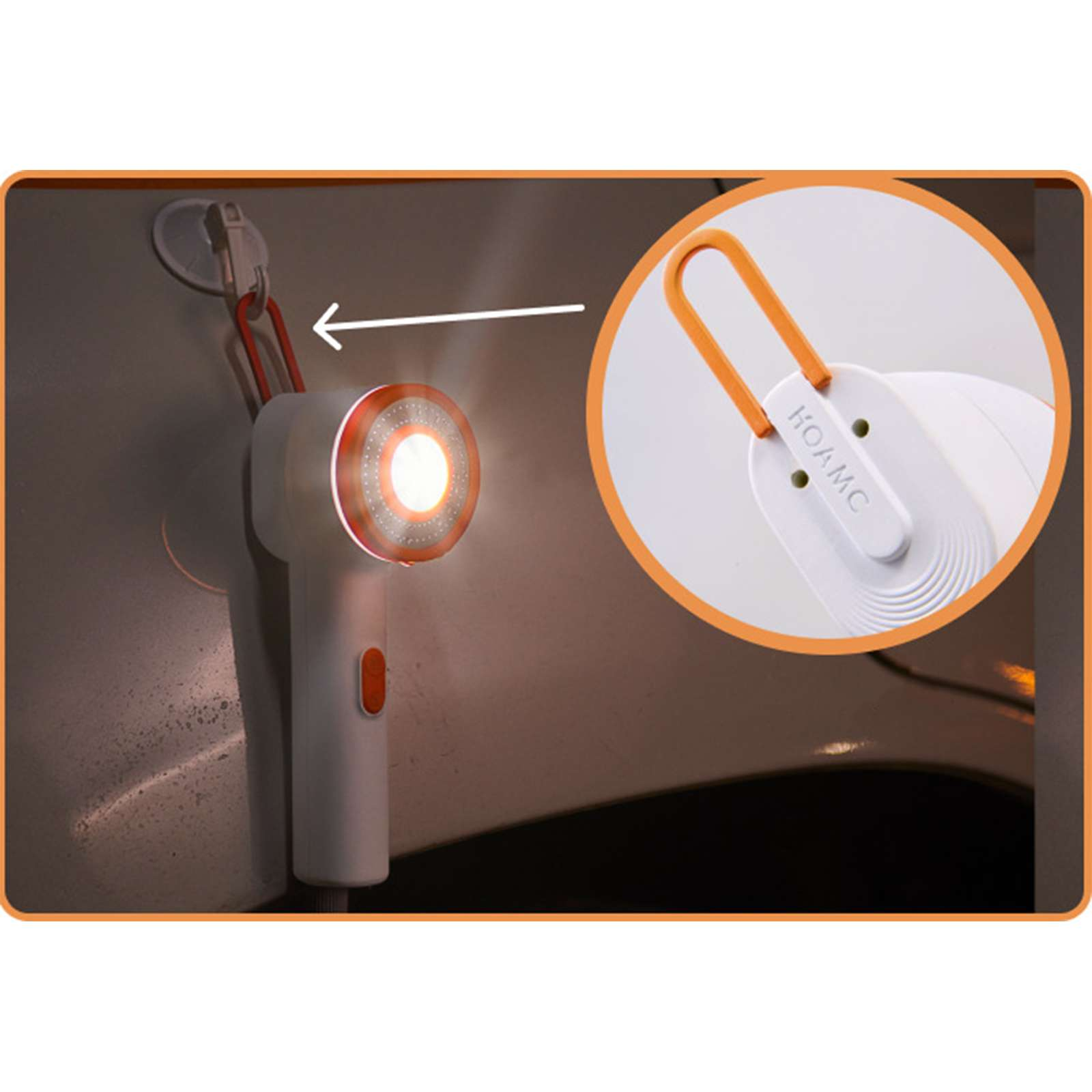 Ein weißes und orangefarbenes Licht hängt an der Wand. Es hat einen orangefarbenen Griff und Knopf. Das Licht ist an.