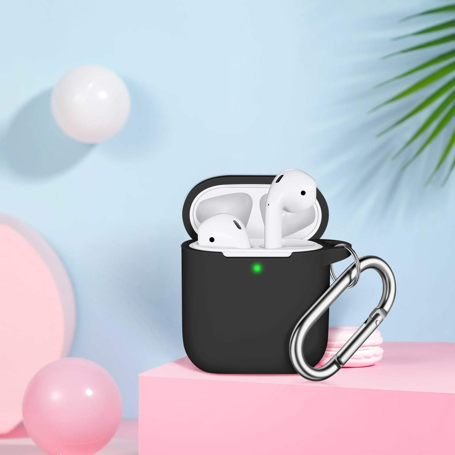 Schwarzes AirPods-Etui mit weißen Ohrhörern, silbernem Clip, rosa und weißen Kugeln und blauem Hintergrund.