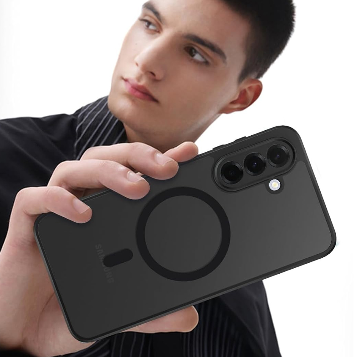 Ein Mann hält ein schwarzes Telefon mit Hülle. Das Telefon hat eine runde magnetische Befestigung. Der Mann trägt ein schwarzes Hemd.