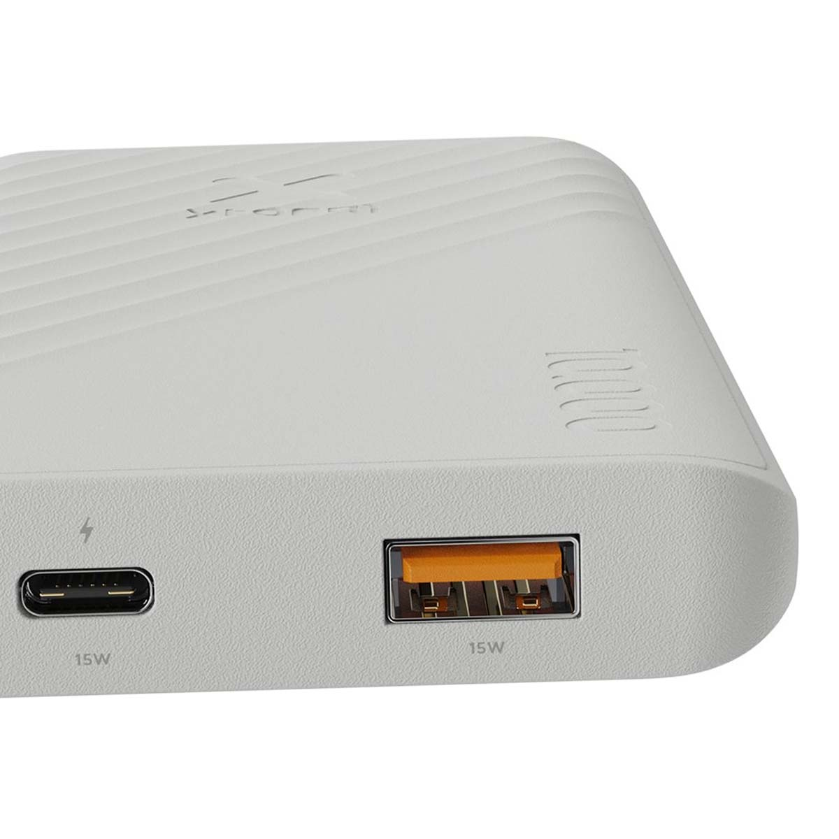 Une batterie externe blanche avec deux ports étiquetés 15W. L'un est USB-C, l'autre USB-A. Le dessus a des lignes en retrait.