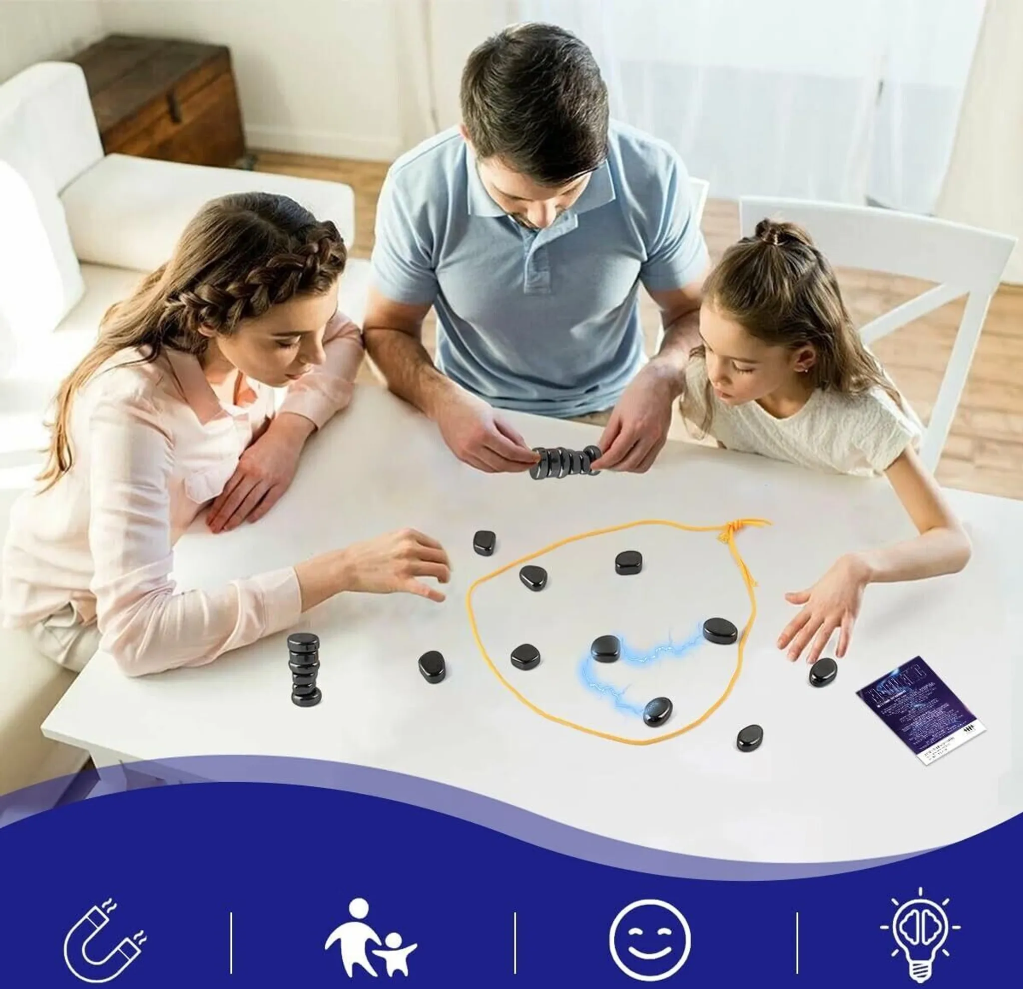 Eine Familie spielt ein Spiel mit schwarzen Steinen auf einem weißen Tisch. Eine Karte und eine gezeichnete Kontur sind ebenfalls auf dem Tisch.