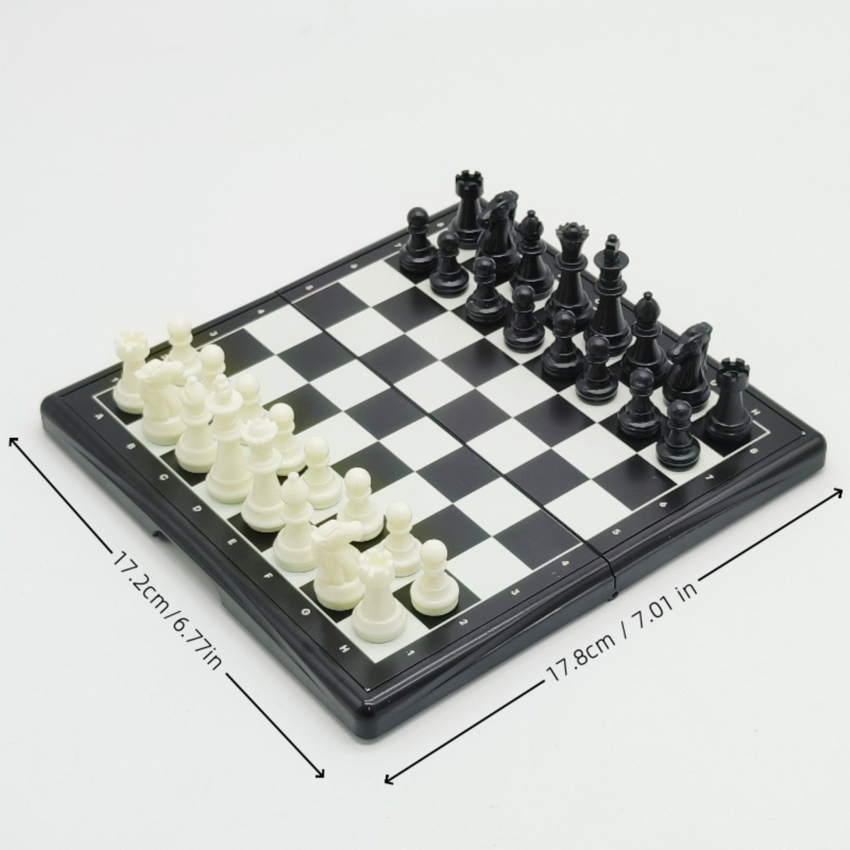 Schachspiel mit schwarzen und weißen Figuren auf einem karierten Brett. Abmessungen sind angegeben.