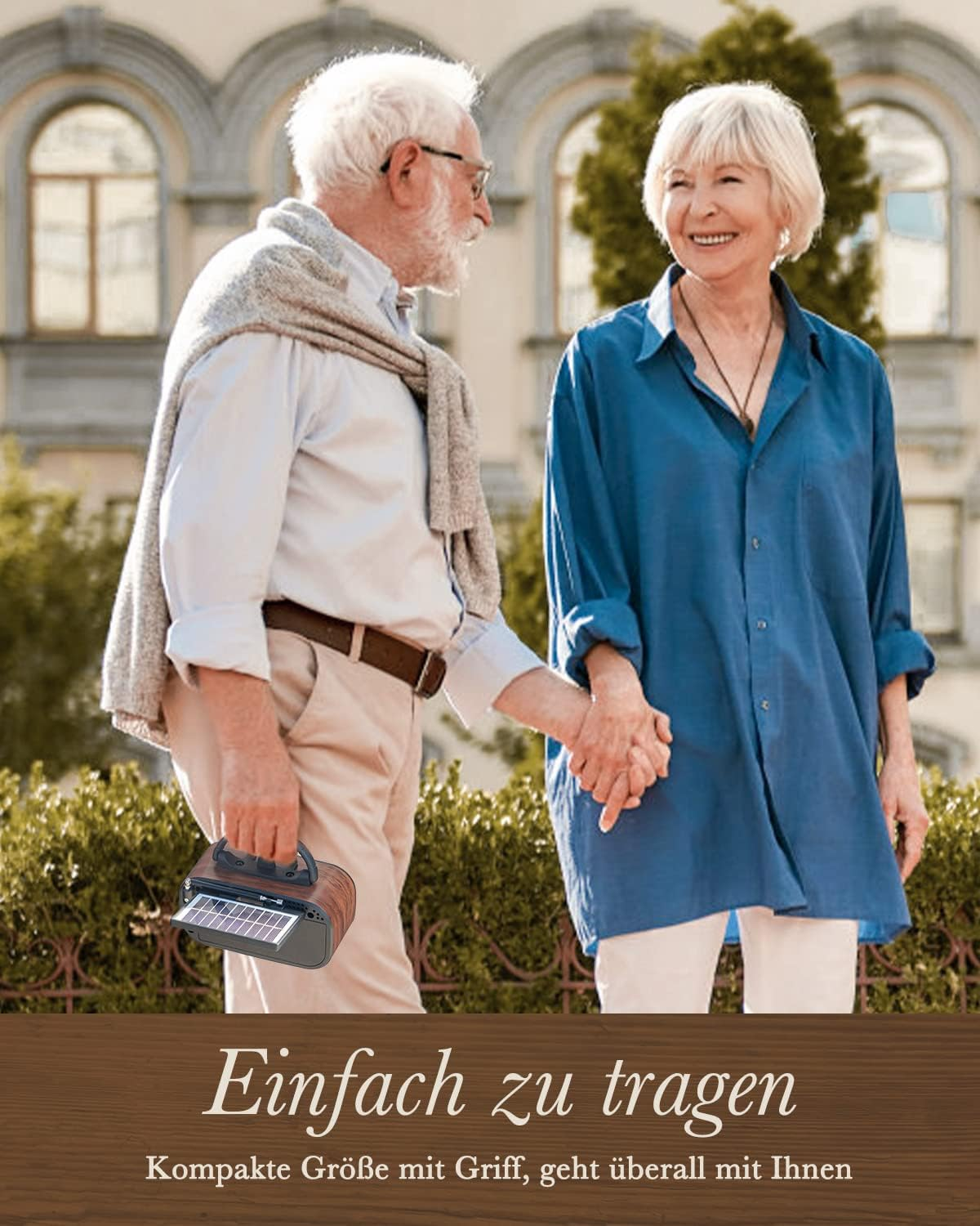 Starsza para trzymająca się za ręce. Mężczyzna trzyma radio solarne. Idą ścieżką, budynki w tle.