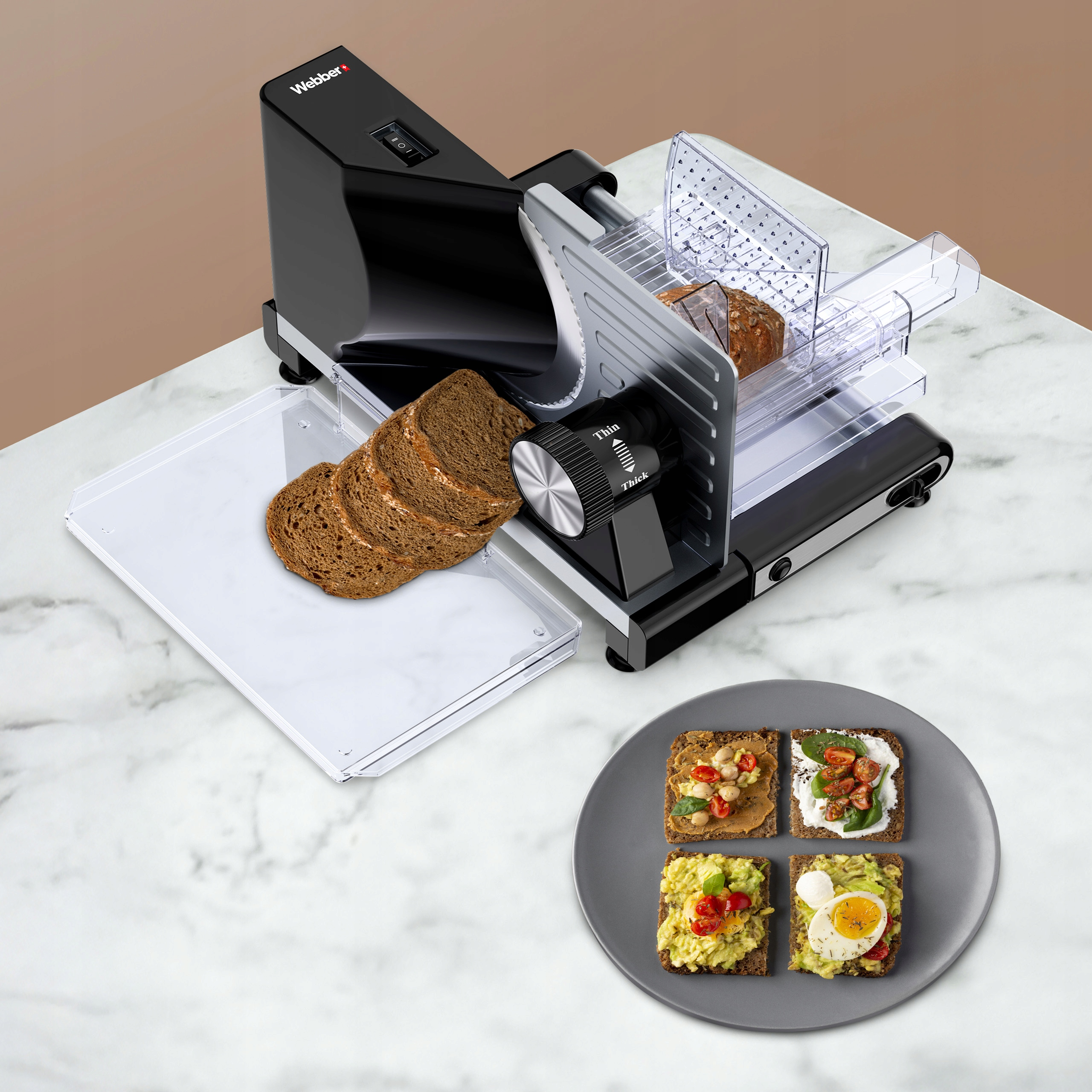 Czarna krajalnica do chleba z pokrojonym chlebem i talerzem tostów z różnymi dodatkami.