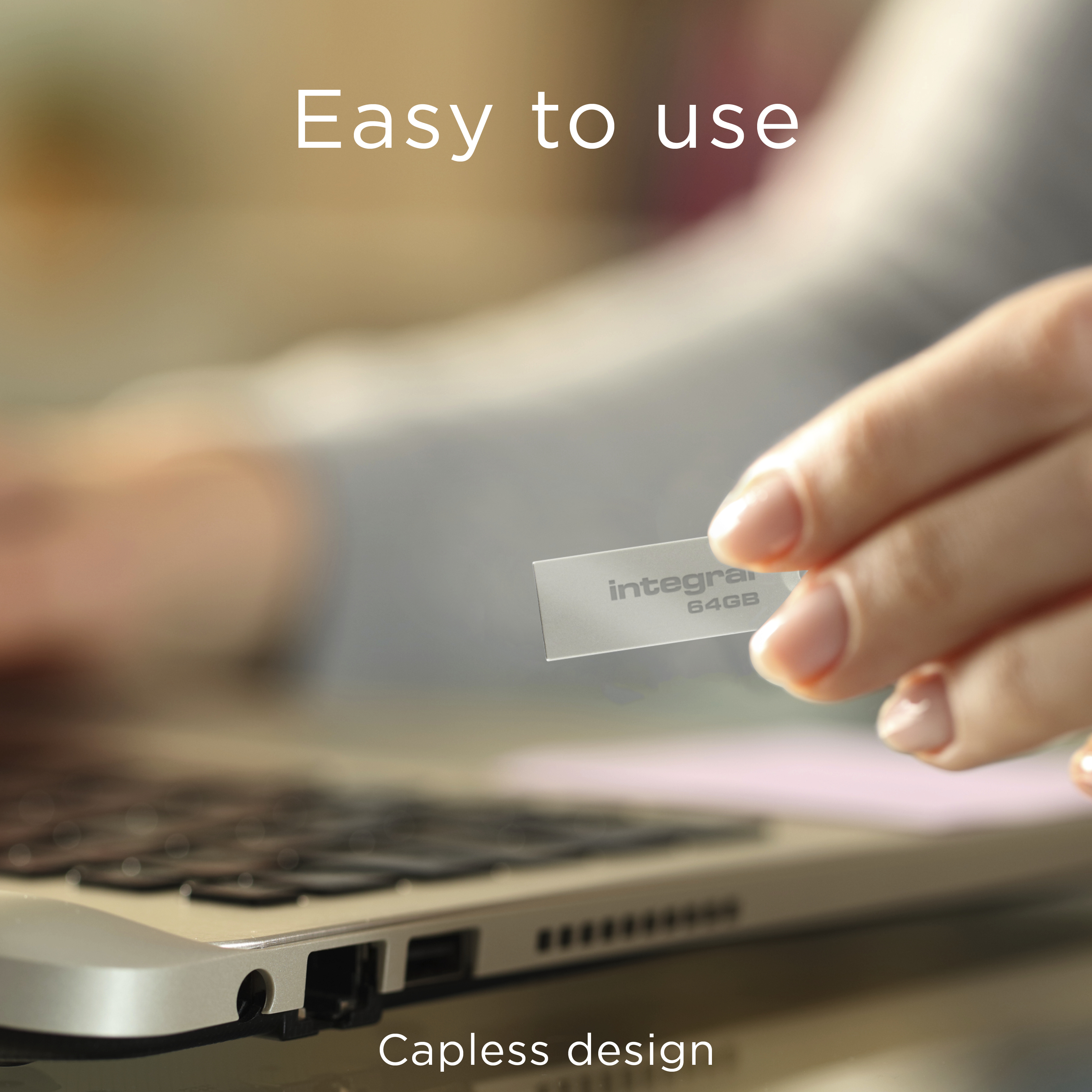 A hand holds a silver USB drive near a laptop. The drive is labeled 'integra 64GB'. The text 'Easy to use' is above.