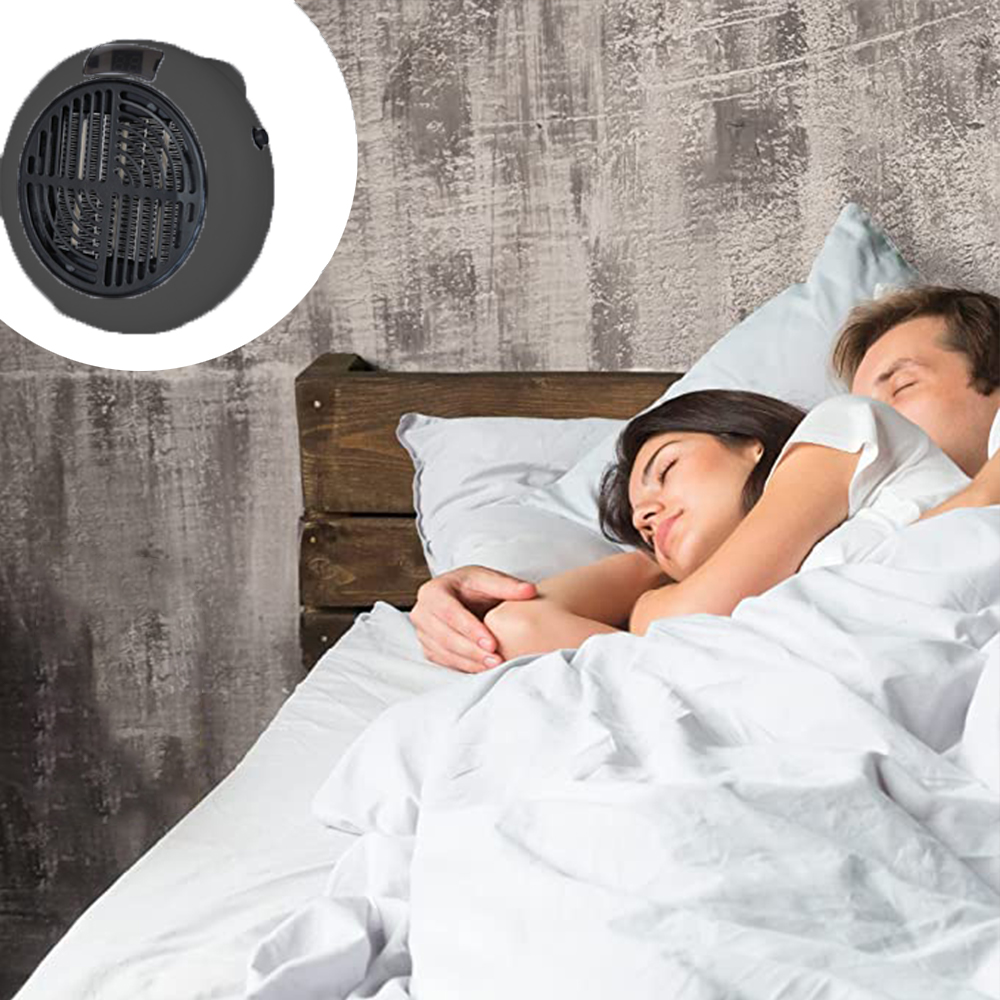 Ein Paar schläft im Bett. Ein kleiner, schwarzer Heizlüfter steht in der Ecke. Weiße Bettwäsche, graue Wand, Holz-Kopfteil.