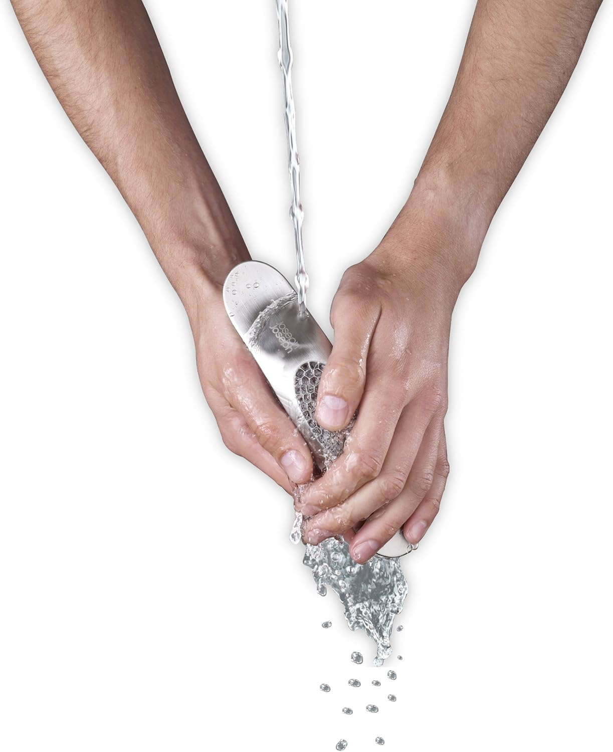 Hände waschen ein Metallobjekt unter fließendem Wasser. Wassertropfen und -strahl sind sichtbar. Weißer Hintergrund.