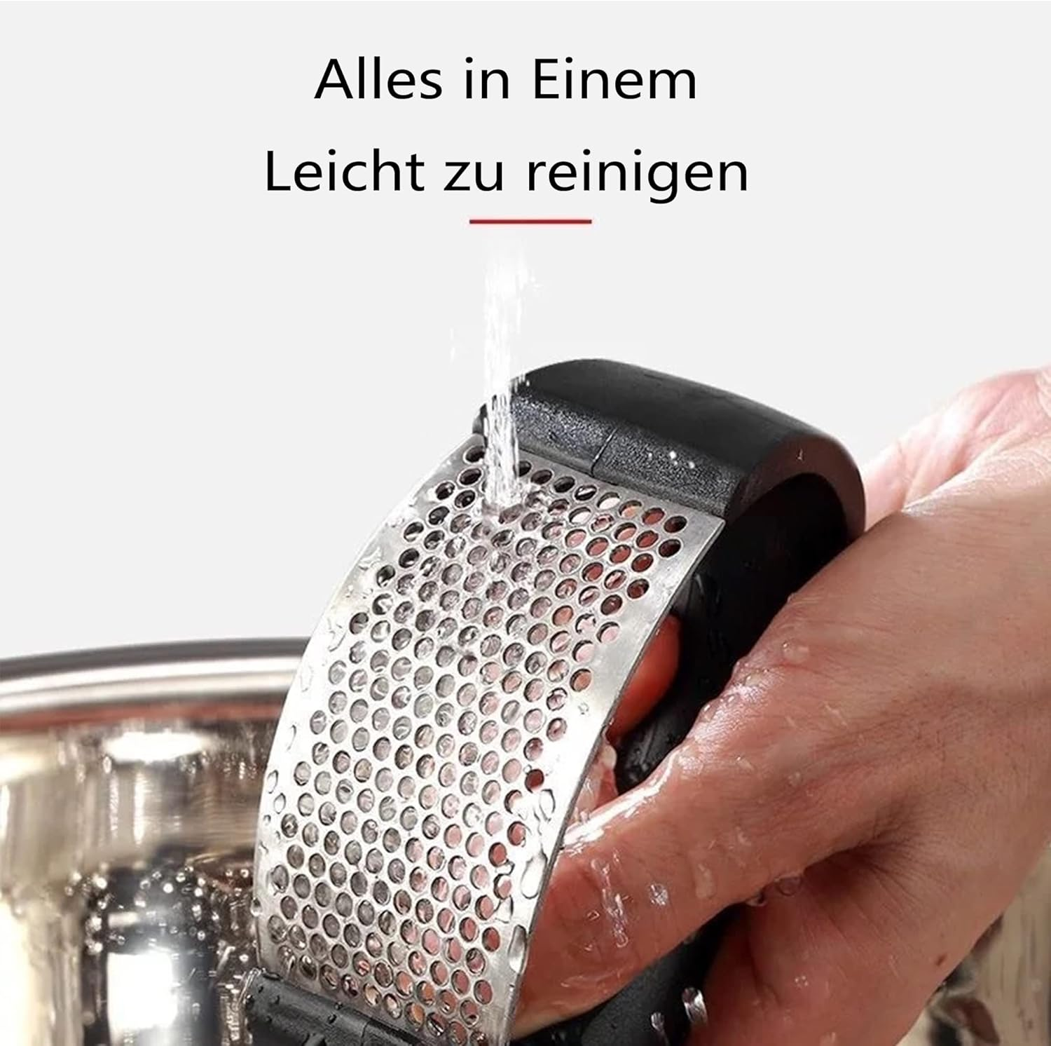 Eine Knoblauchpresse aus Metall wird gewaschen. Wasser fließt durch die Löcher. Text sagt 'Leicht zu reinigen'.