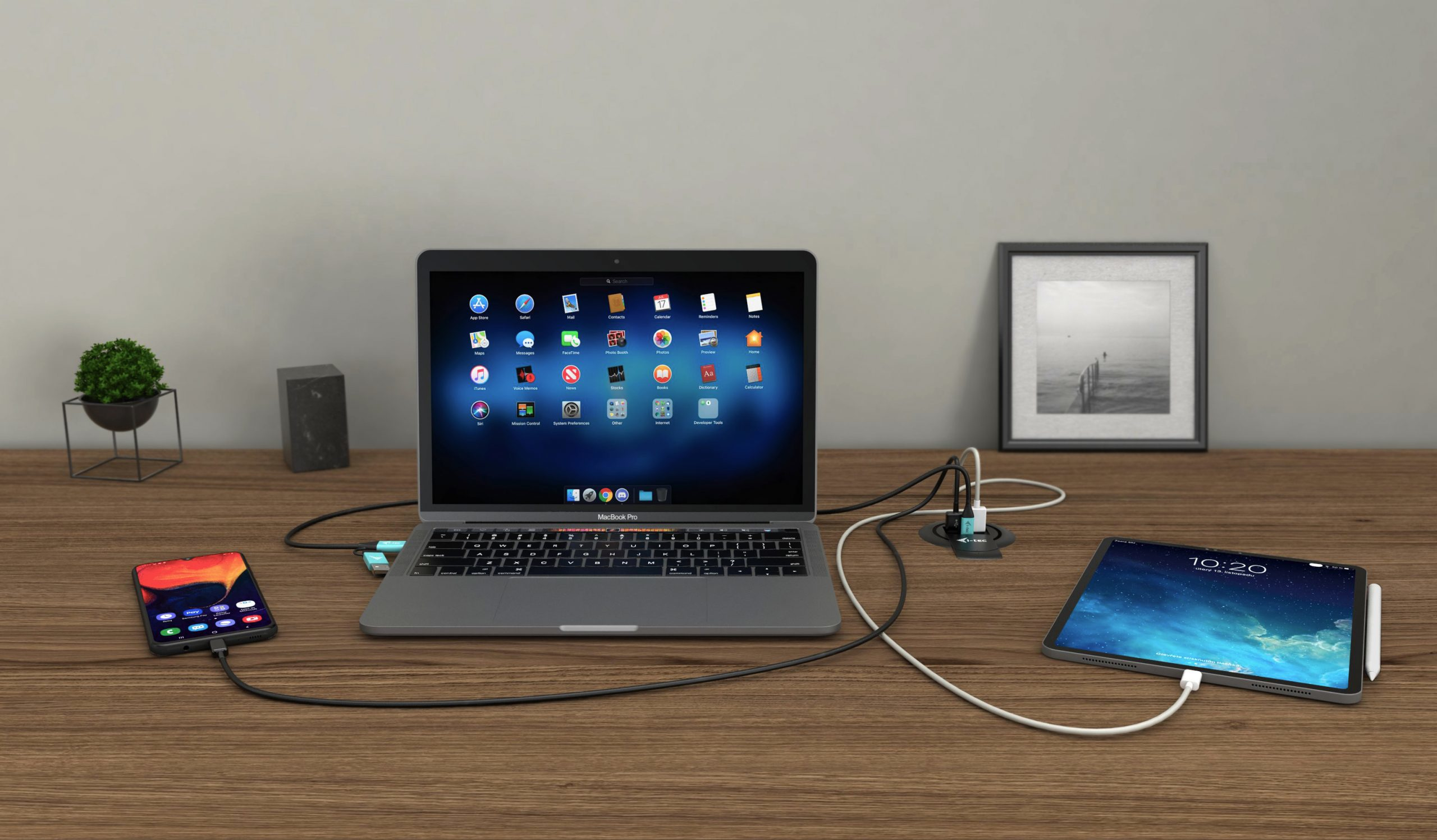 Un ordinateur portable, un téléphone et une tablette sont sur un bureau en bois. L'écran de l'ordinateur portable affiche des icônes d'applications, la tablette l'heure.