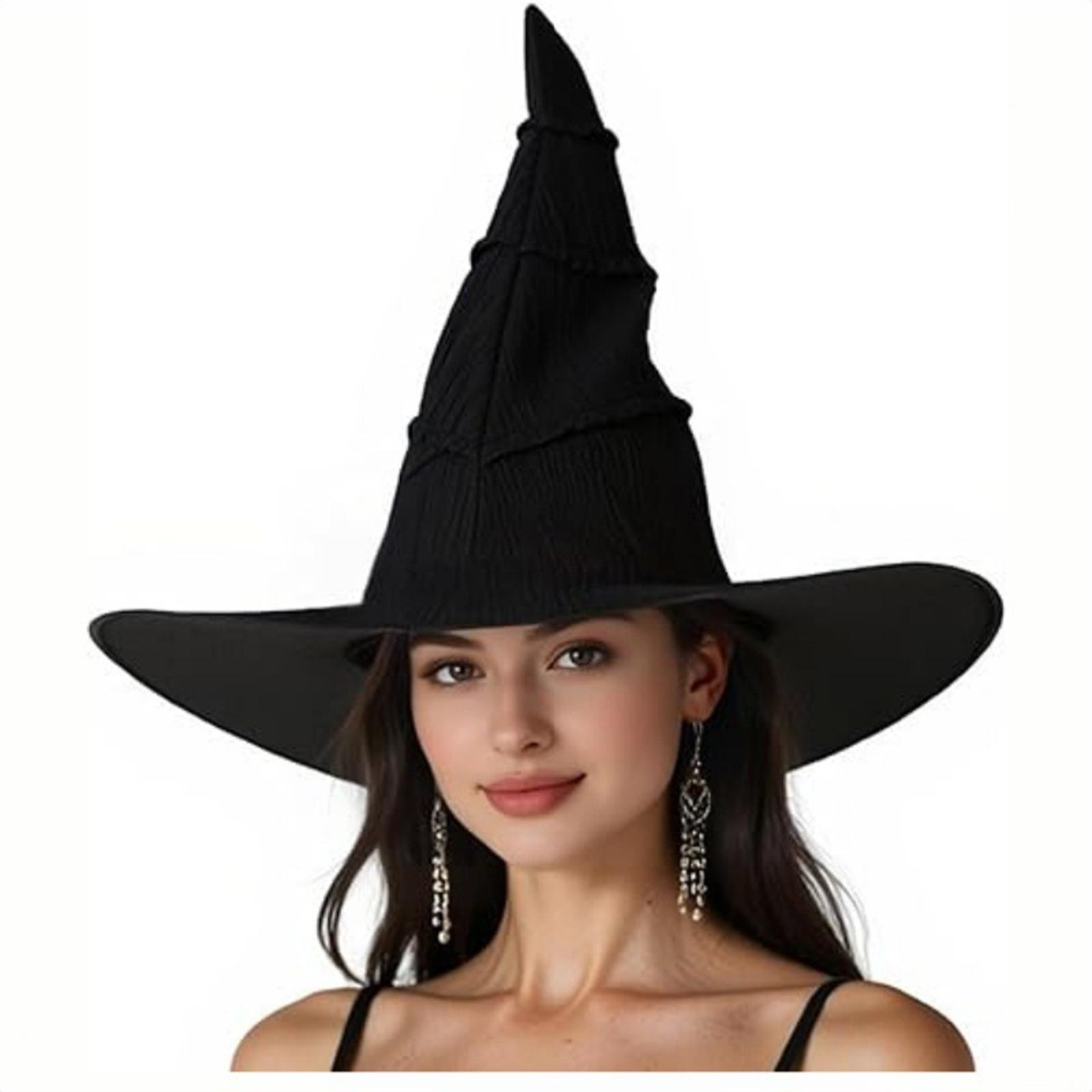 Eine Frau mit schwarzem Hexenhut und Ohrringen, lächelnd. Der Hintergrund ist weiß.
