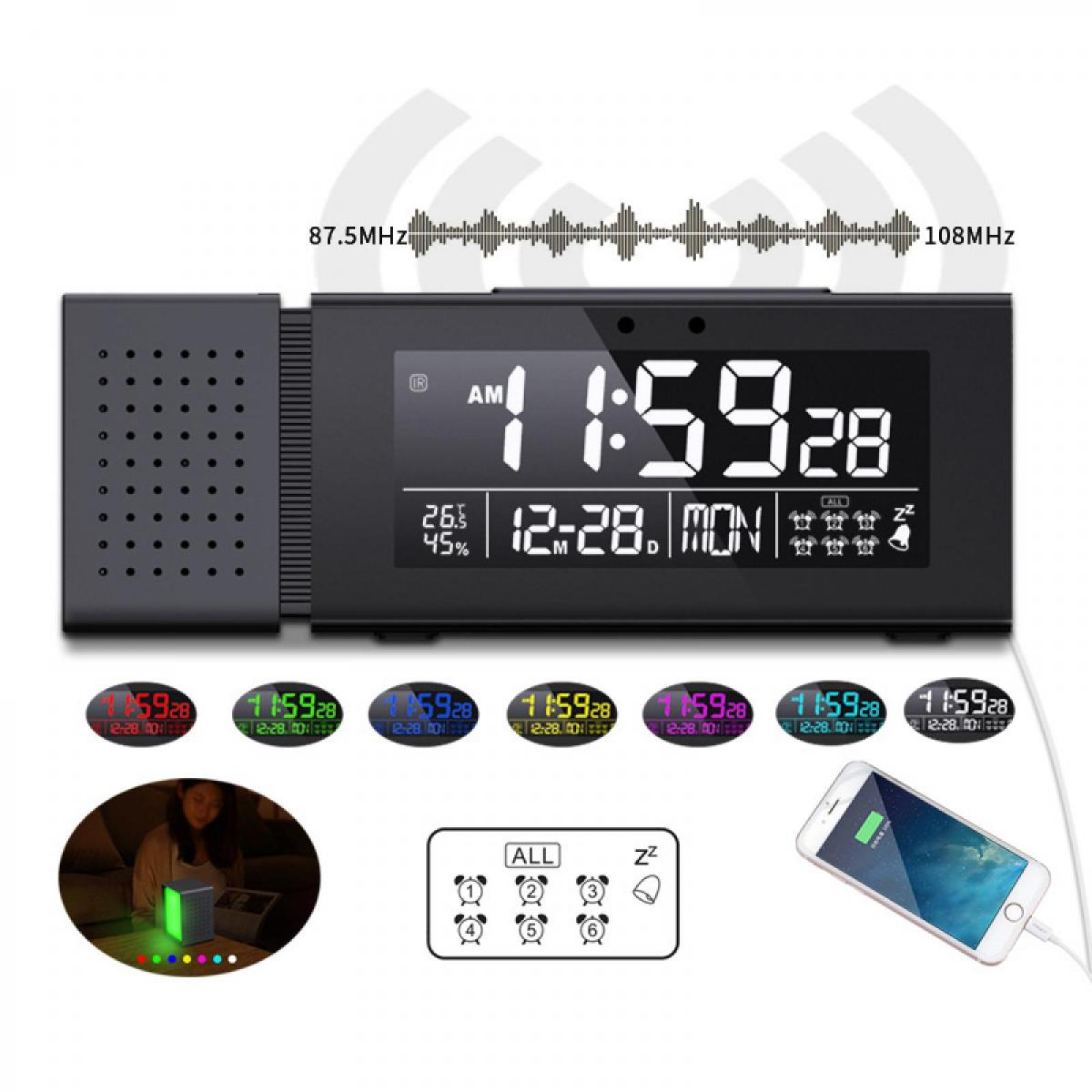 Eine schwarze Digitaluhr zeigt 11:59:28 mit Temperatur und Datum an. Darunter kleinere Uhren. Rechts lädt ein Telefon.