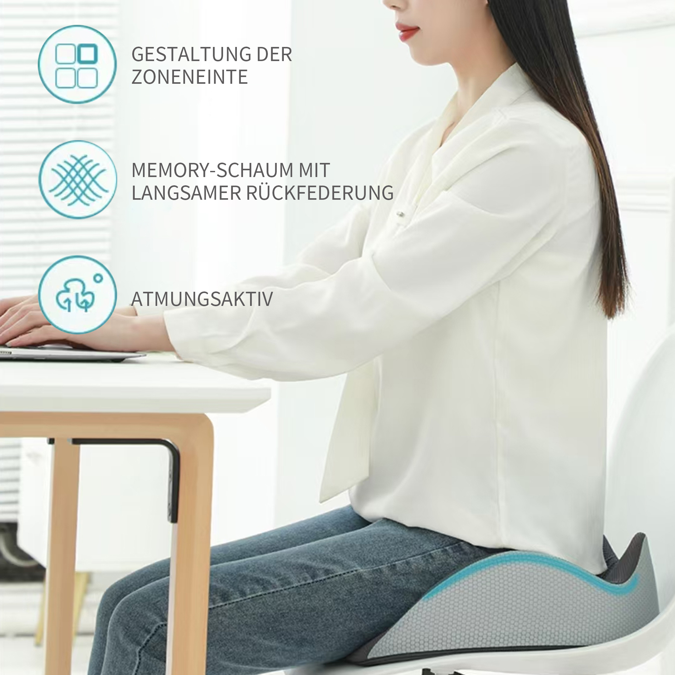 Eine Frau sitzt auf einem Stuhl mit einem Kissen und arbeitet an einem Laptop an einem weißen Schreibtisch.