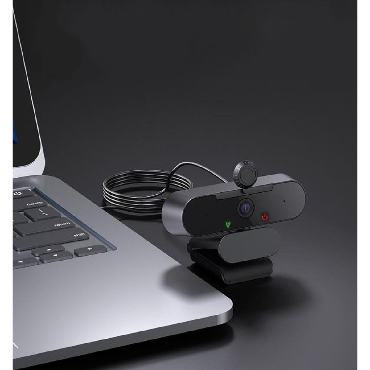 Eine Webcam ist an einem Laptop befestigt. Die Webcam ist schwarz und hat eine Linse und Kontrollleuchten. Ein Kabel verbindet sie mit dem Computer.