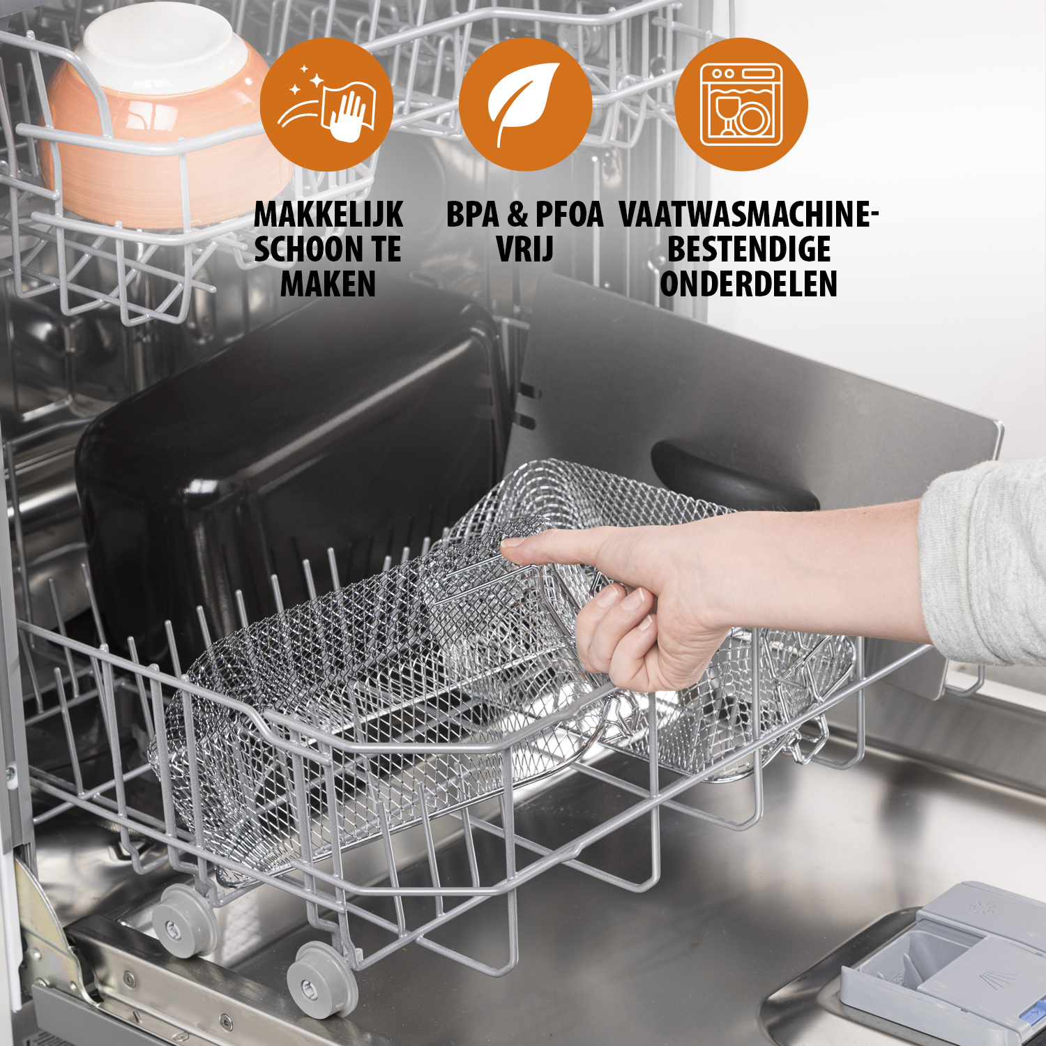 Wnętrze zmywarki z dłonią wskazującą na metalowy kosz. Jest miska, czarny pojemnik i etykiety tekstowe powyżej.