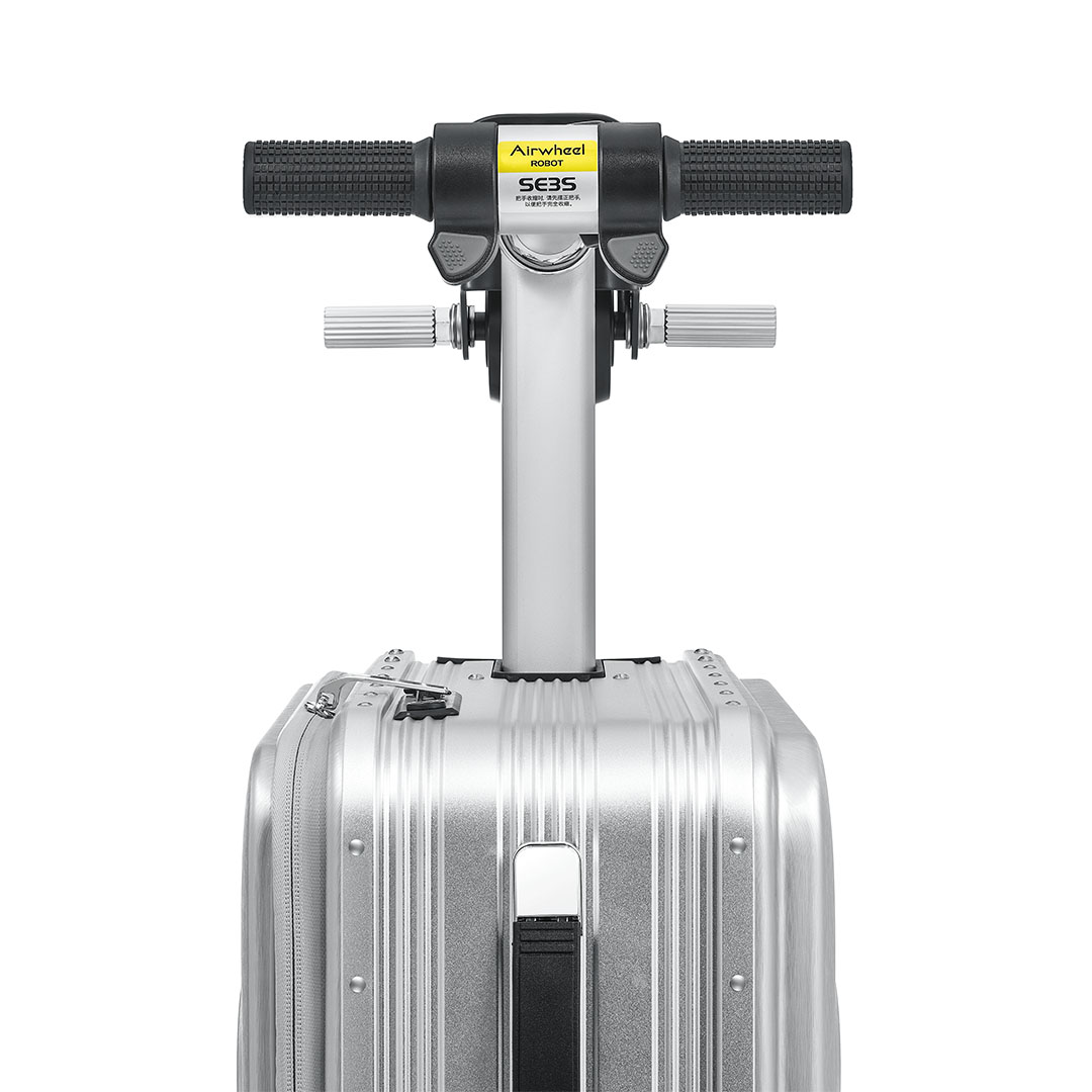 Eklenmiş bir Airwheel robotu olan gümüş bir bavul. Robotun siyah kulpları ve bir kontrol paneli var. Bavul kapalı.